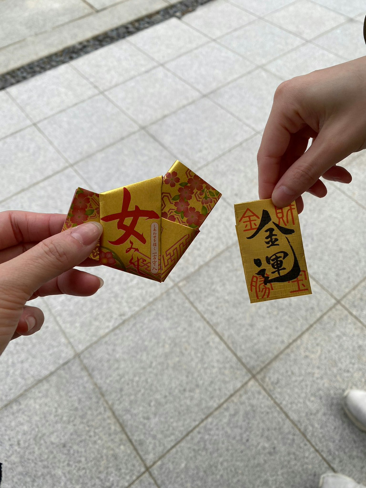 手中握著的兩個色彩鮮豔的護身符展示獨特的設計和符號