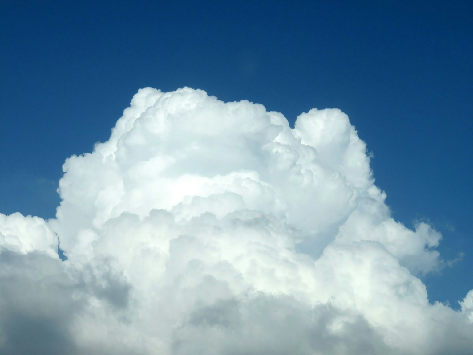 Awan putih berbulu lembut di latar belakang langit biru
