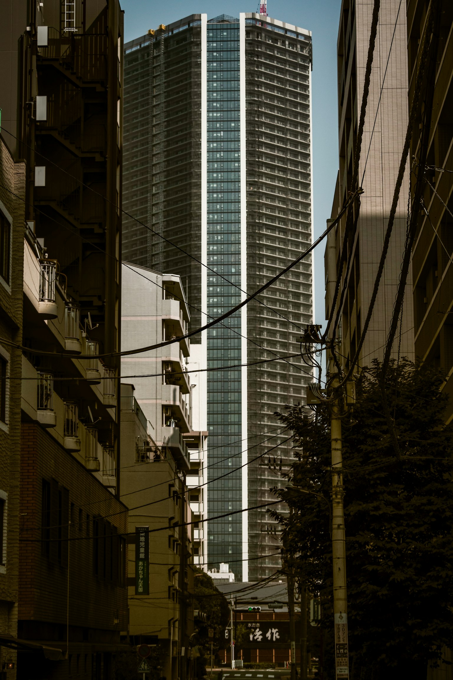 Un rascacielos que se eleva sobre una calle estrecha