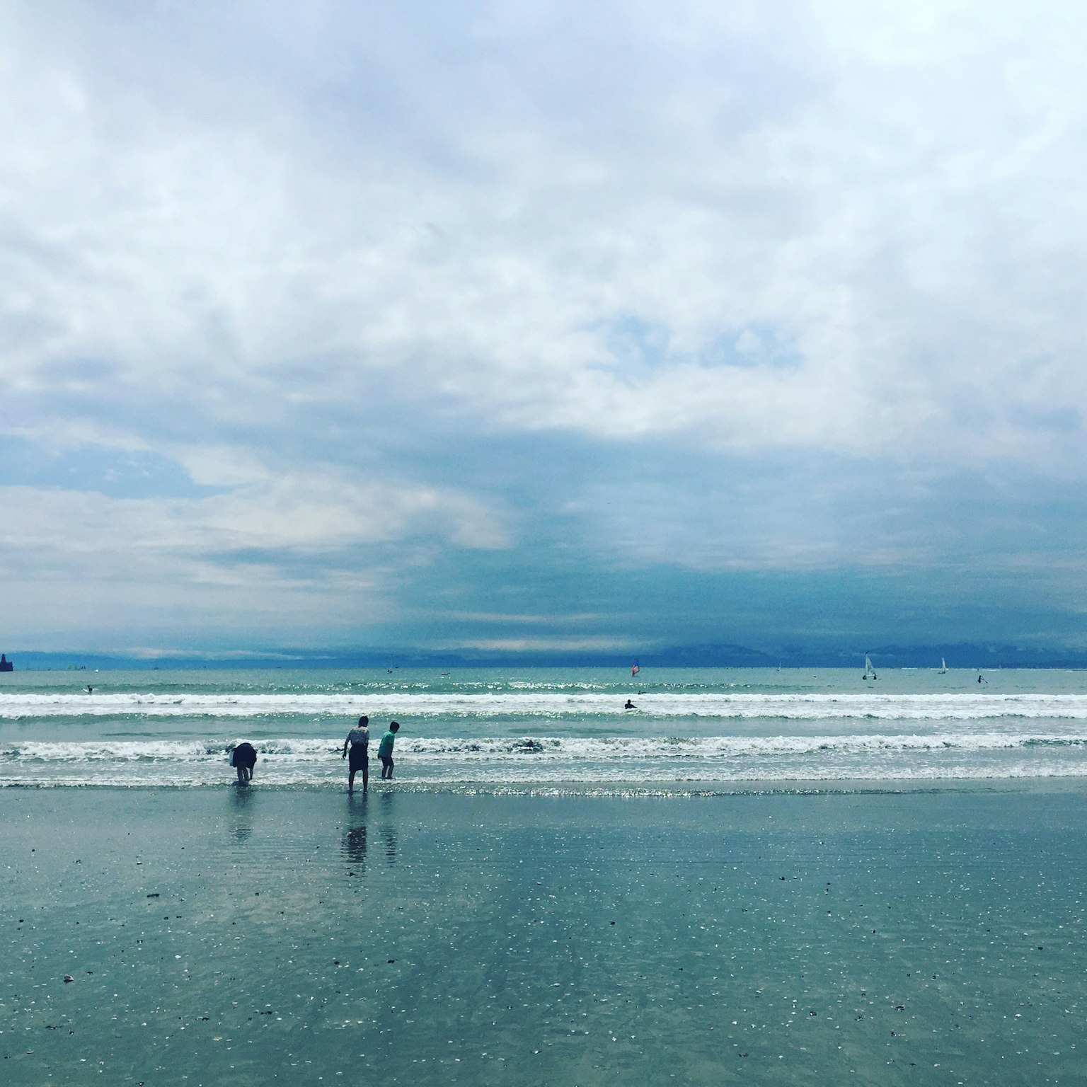 Menschen, die im Ozean unter einem bewölkten Himmel waten