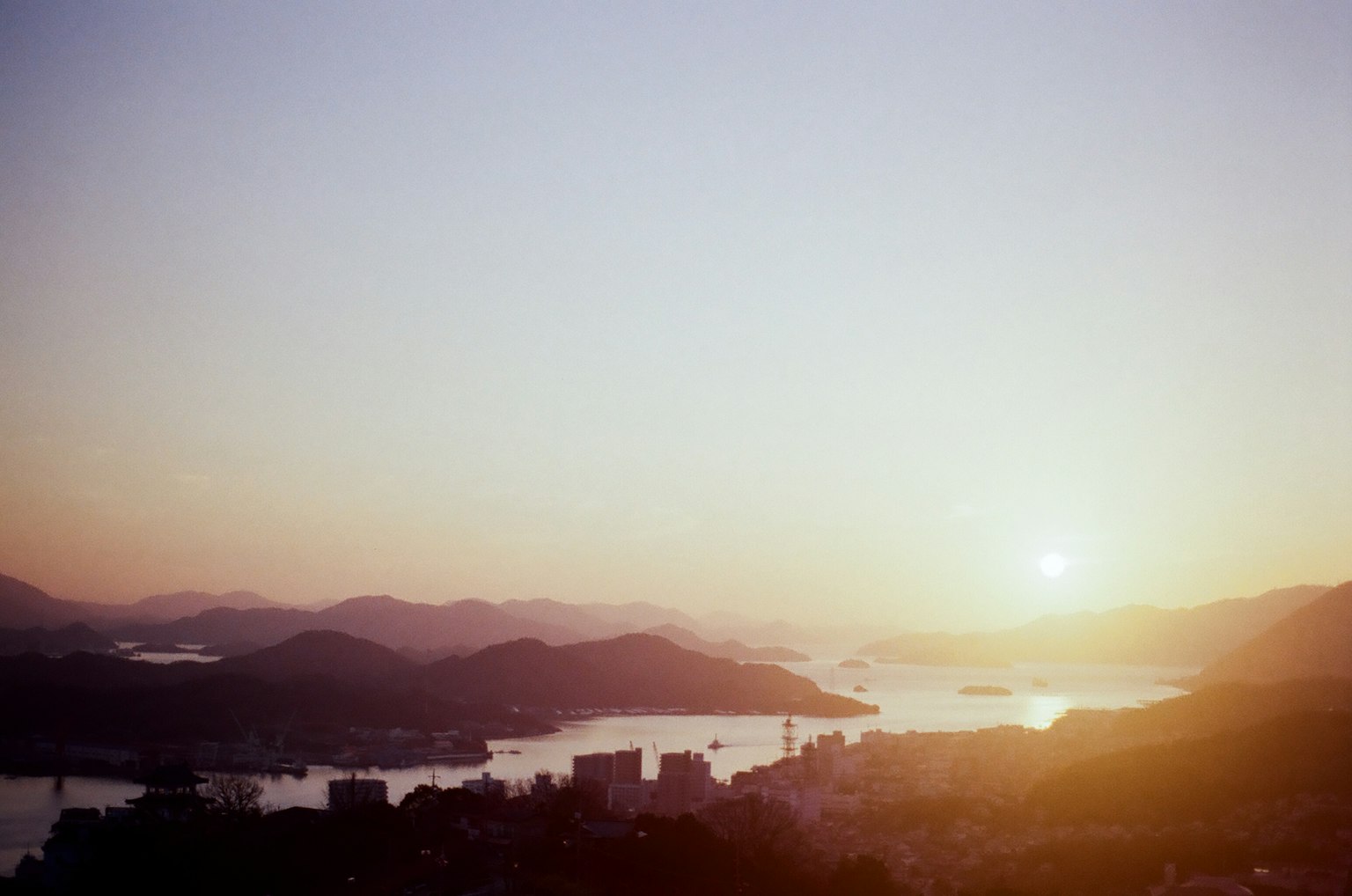 美丽的风景，夕阳在山脉和水体上方