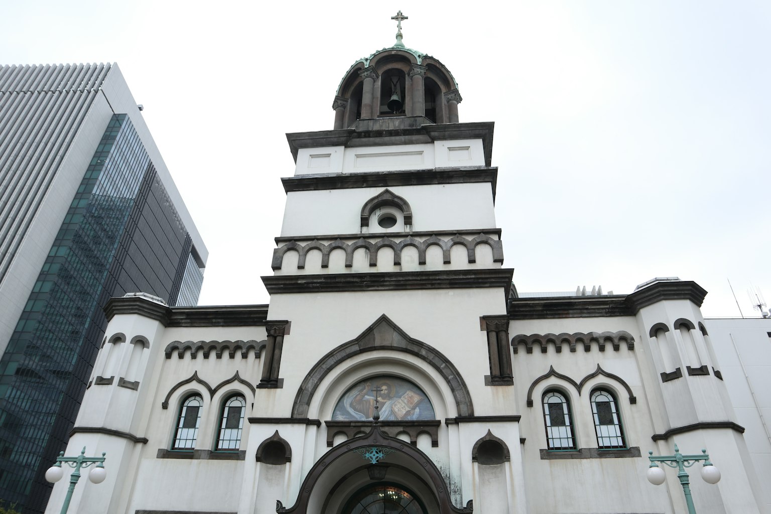 Vista esterna di una chiesa bianca accanto a un edificio moderno