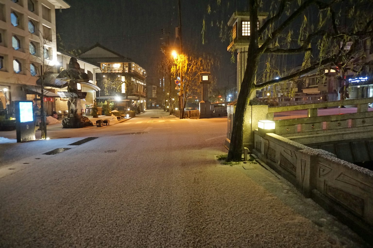 Strada coperta di neve di notte con lampioni luminosi e atmosfera tranquilla