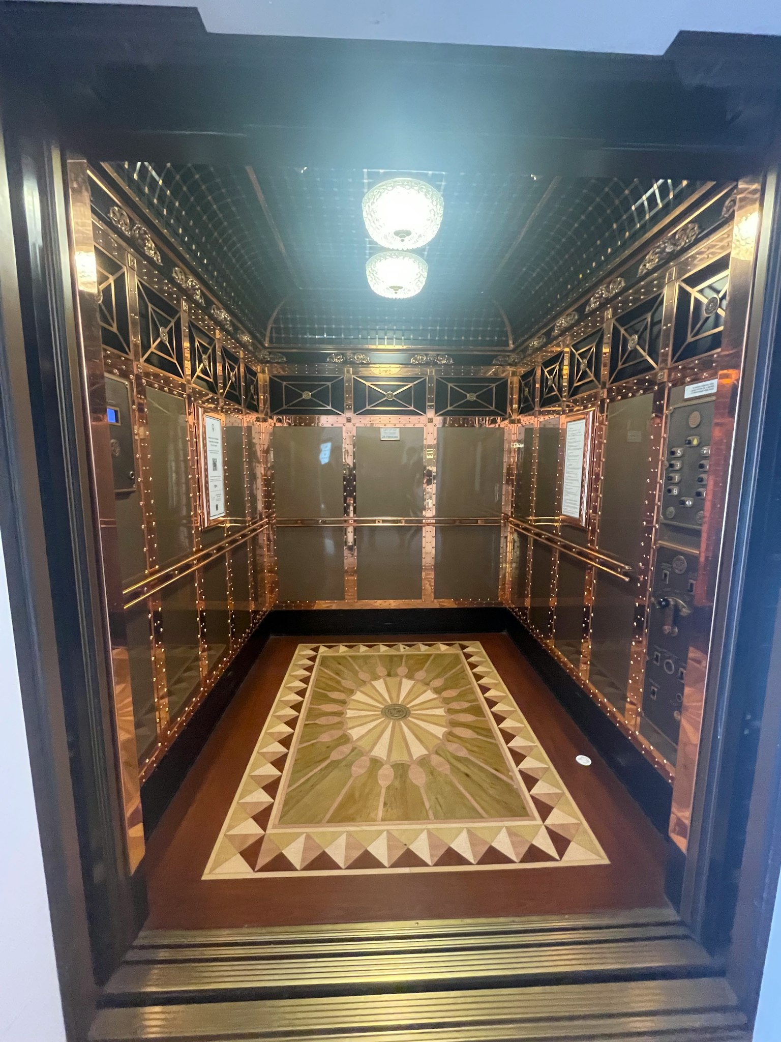 Interiores lujosos de un ascensor con diseños de pared intrincados y piso de mosaico