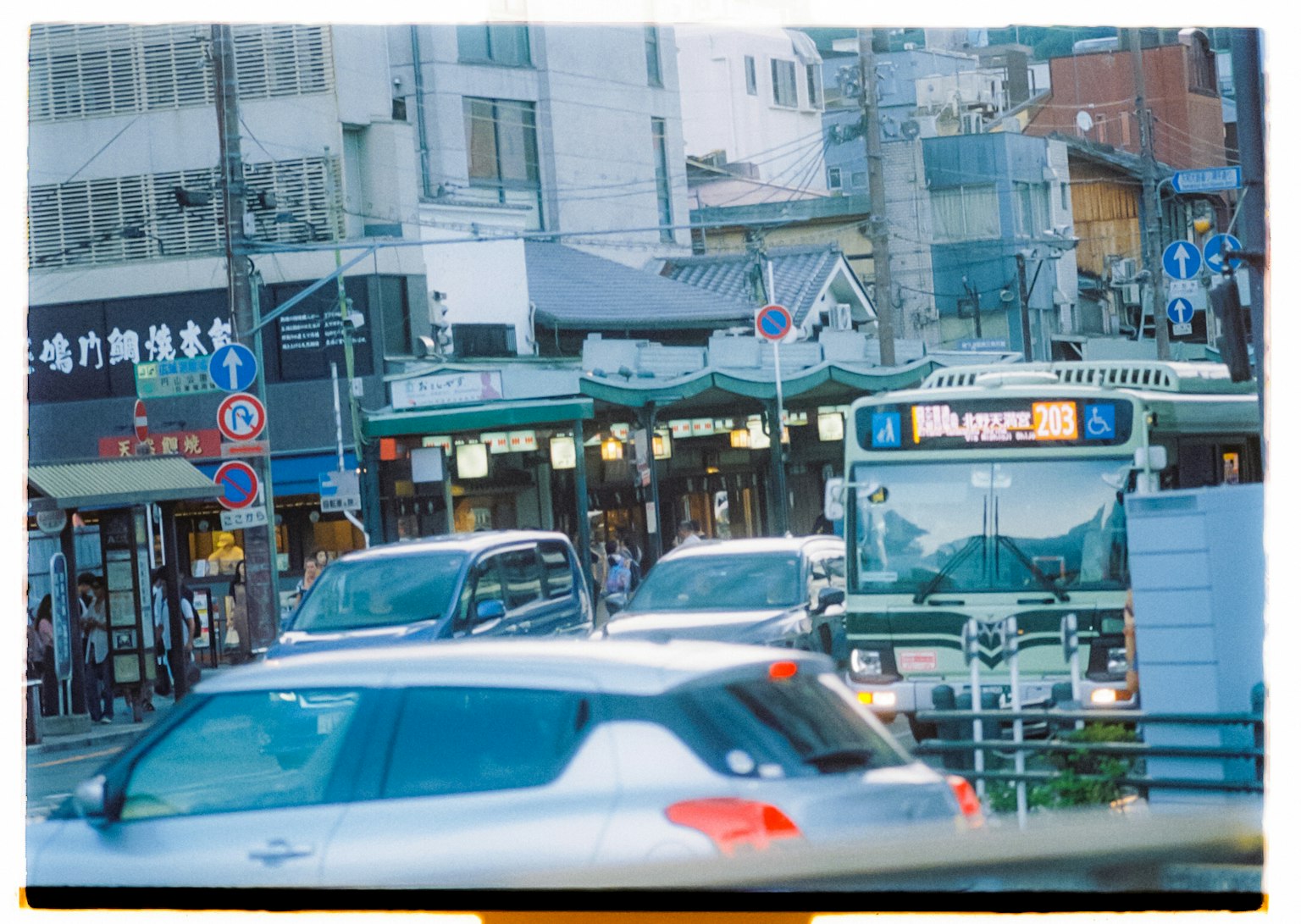 Une scène de rue animée avec un bus et des voitures dans la circulation