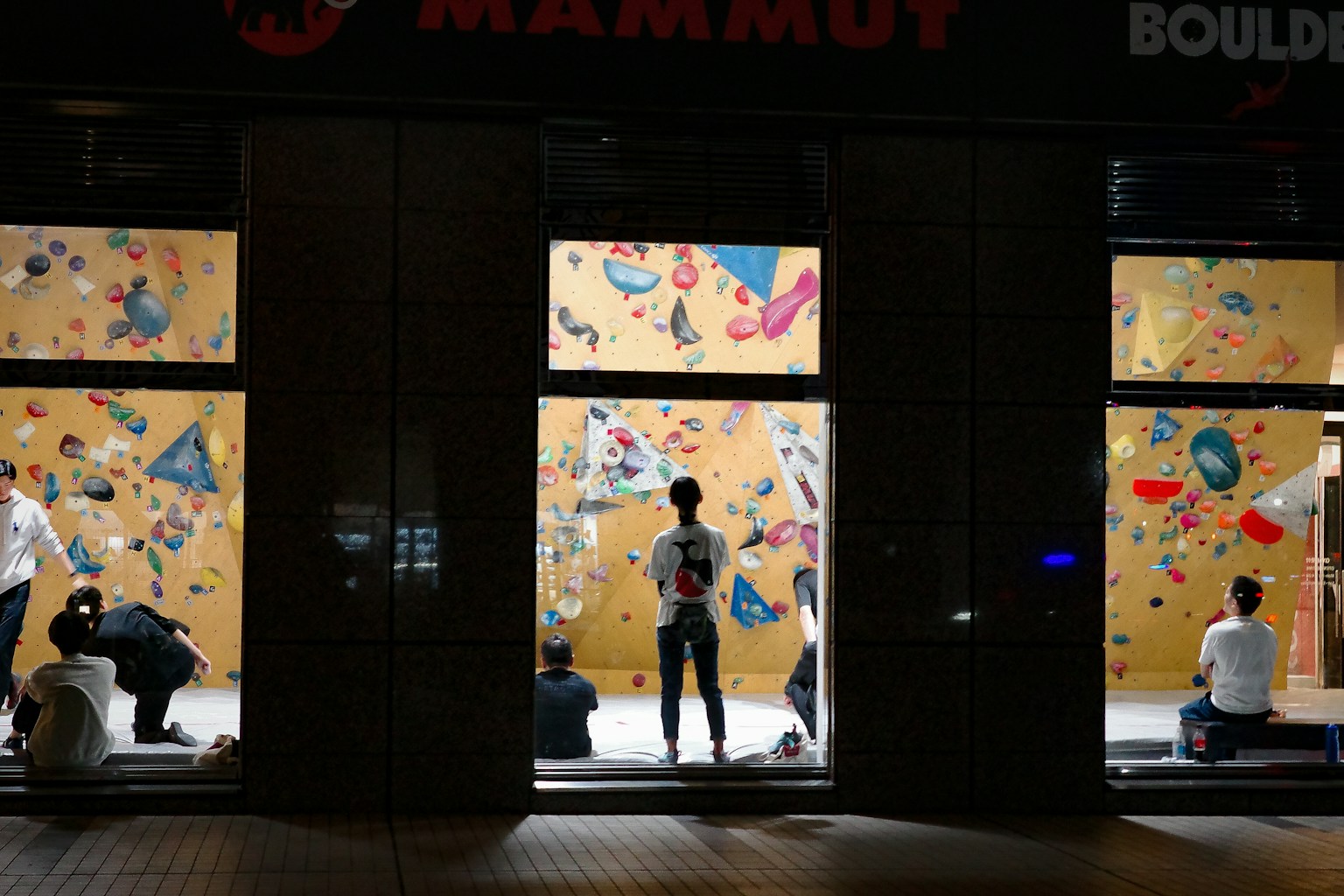 攀岩馆的外观，明亮的攀岩墙在黑暗背景中突出