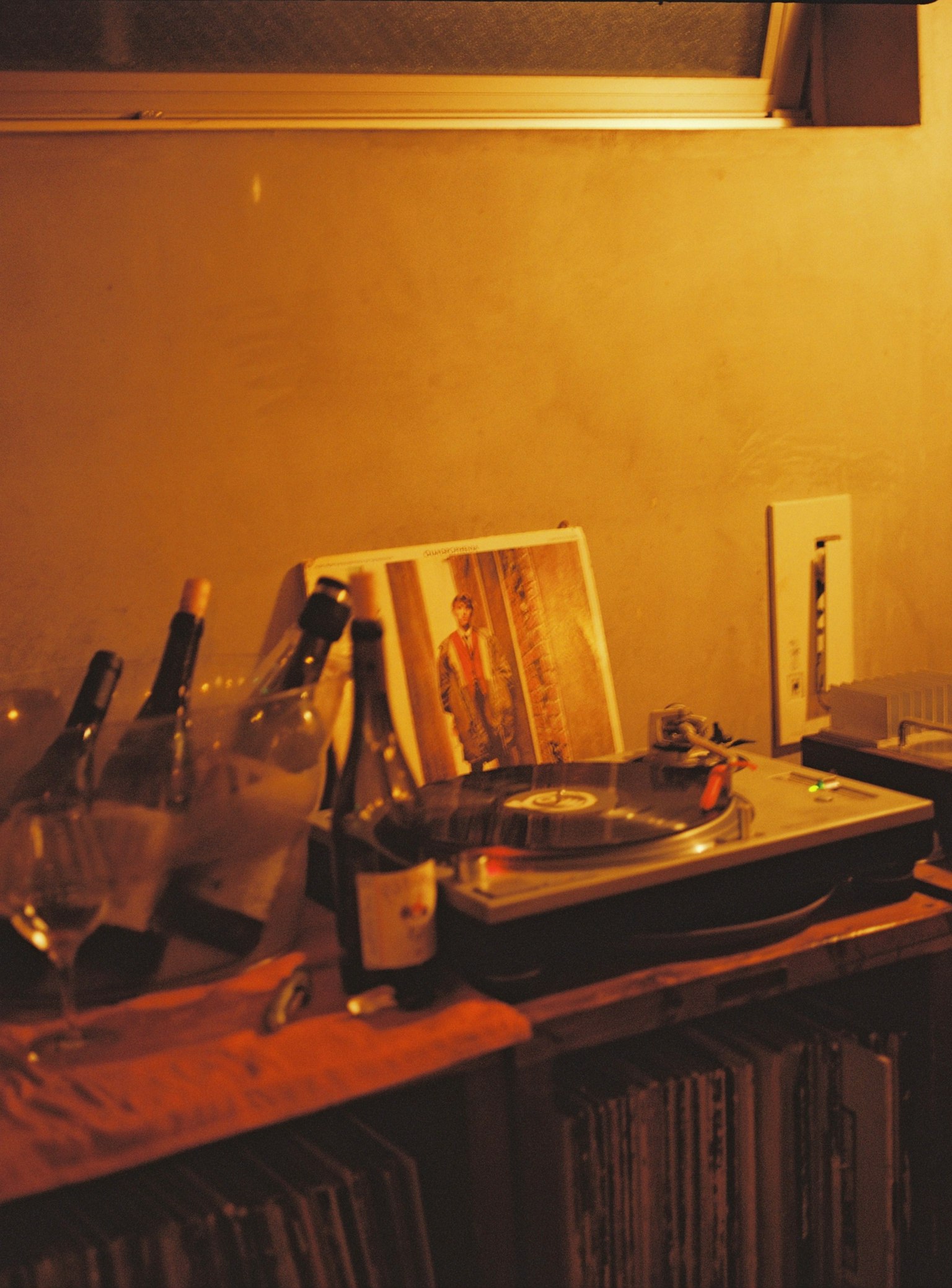Rincón acogedor con un tocadiscos y botellas de vino