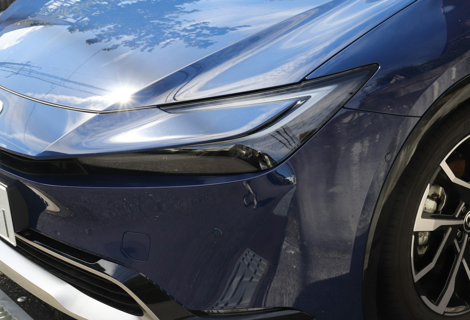 광택이 나는 파란색 차의 앞부분과 매끄러운 헤드라이트