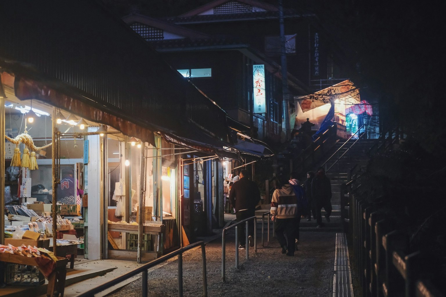 Night market street with shops and people walking