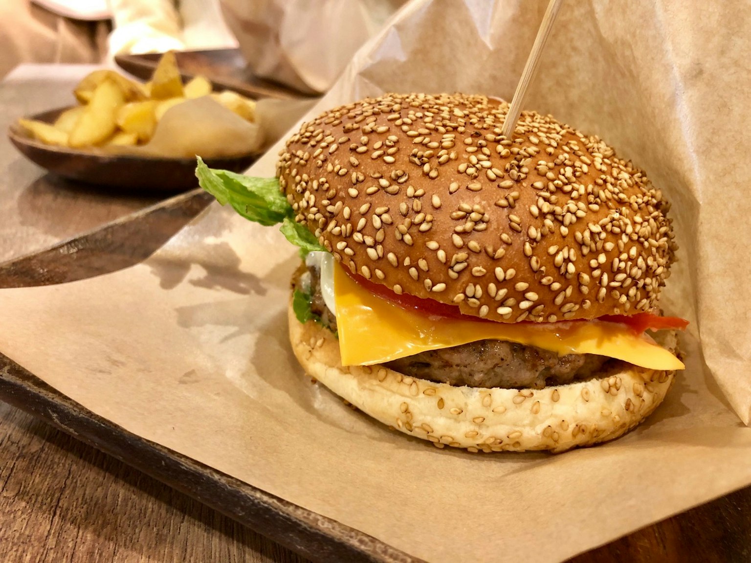 Hamburguesa con semillas de sésamo y queso con guarnición de papas fritas