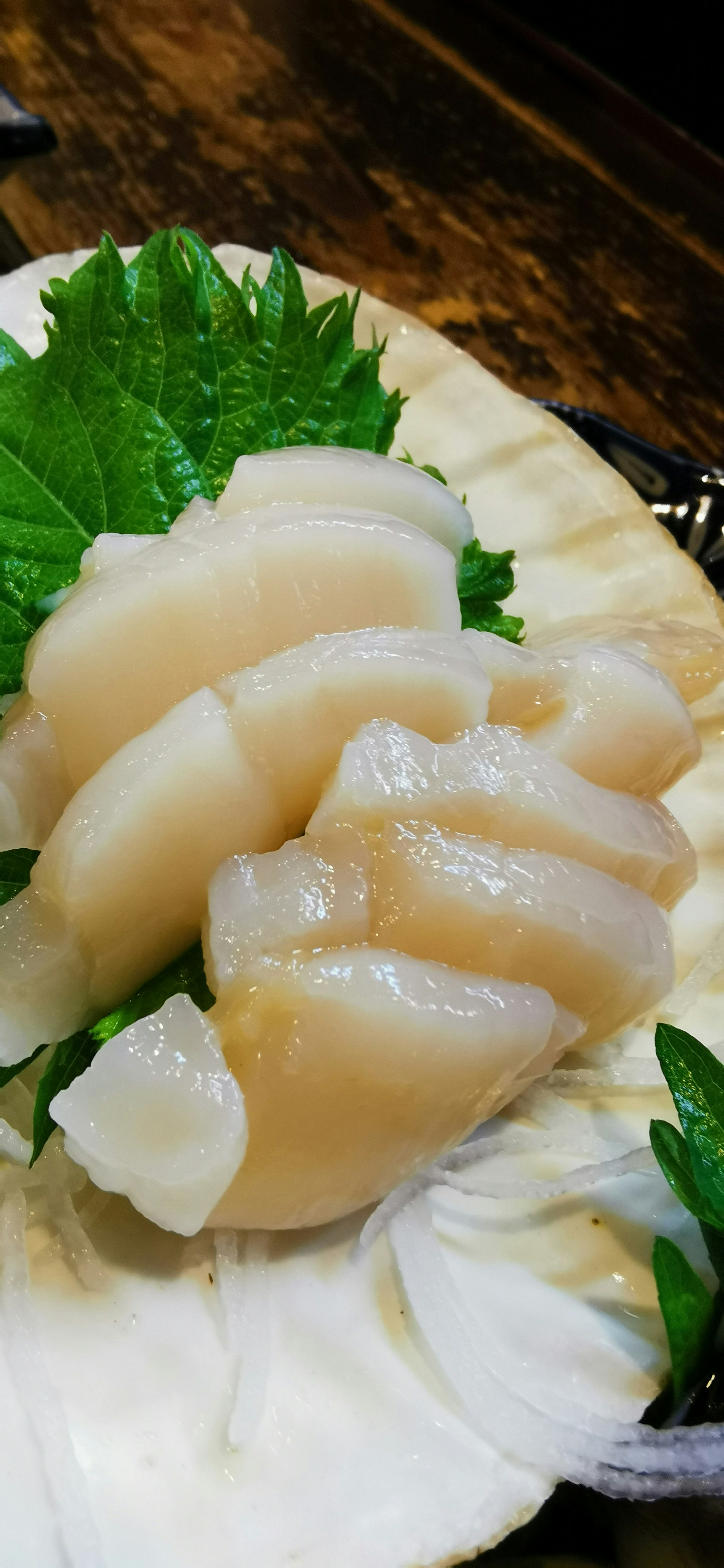 fette di daikon su un piatto bianco con guarnizione di shiso