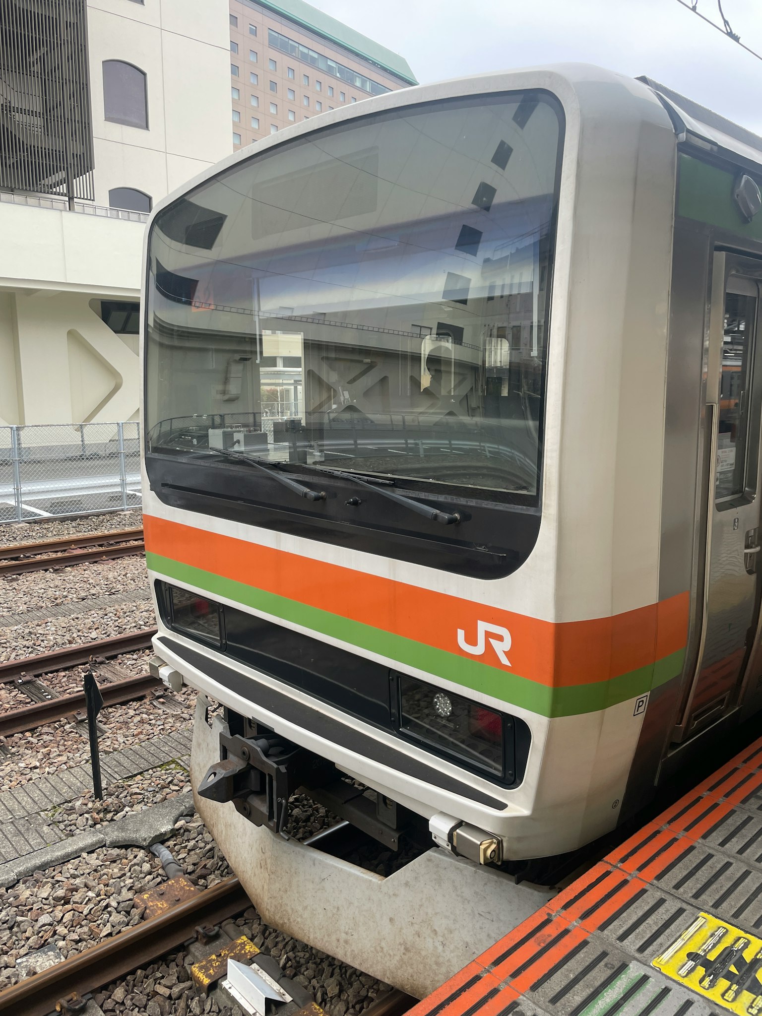 JR列車的正面視圖，具有獨特的橙色和綠色條紋