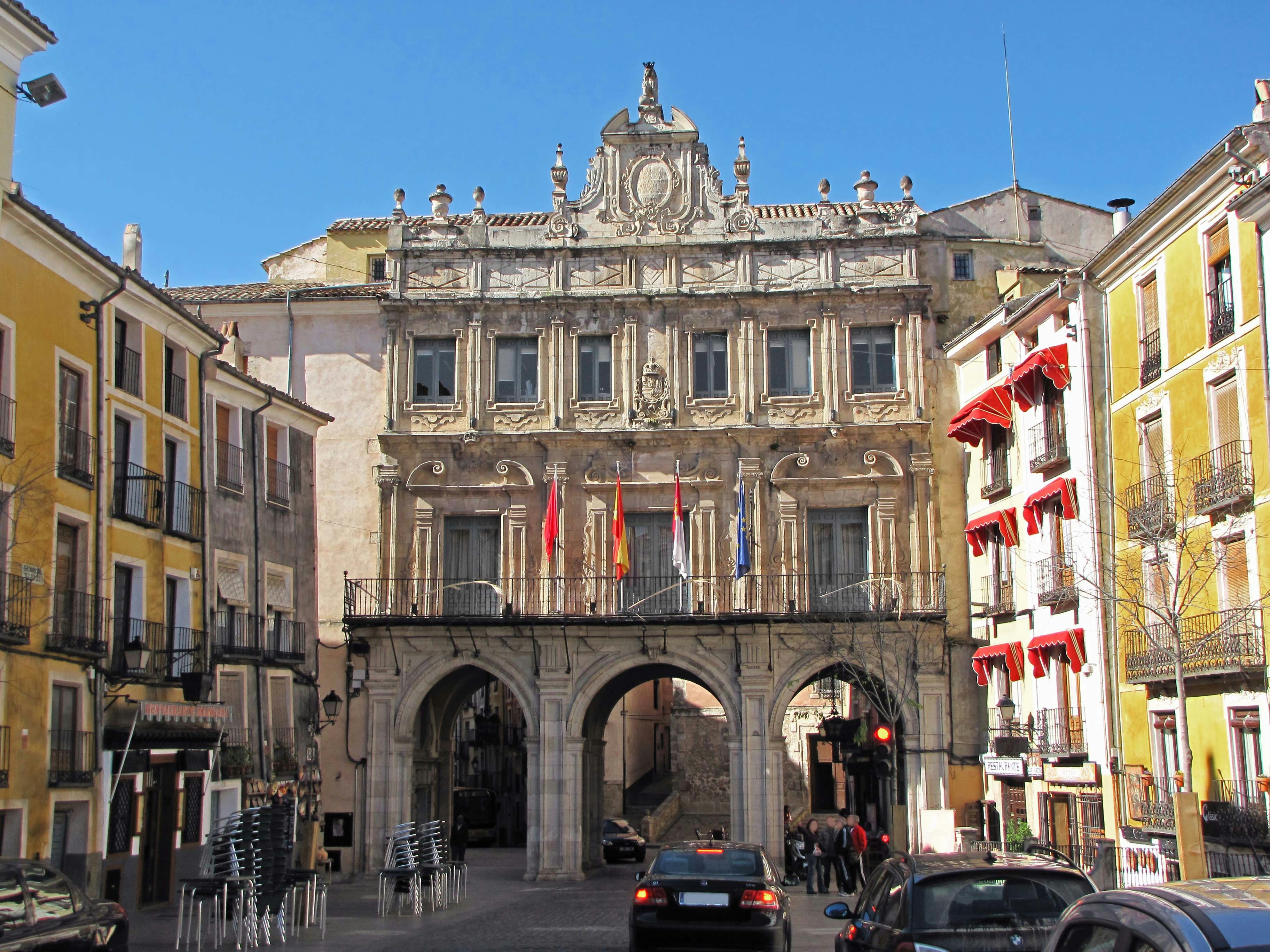 historic stone building with arches facing a plaza