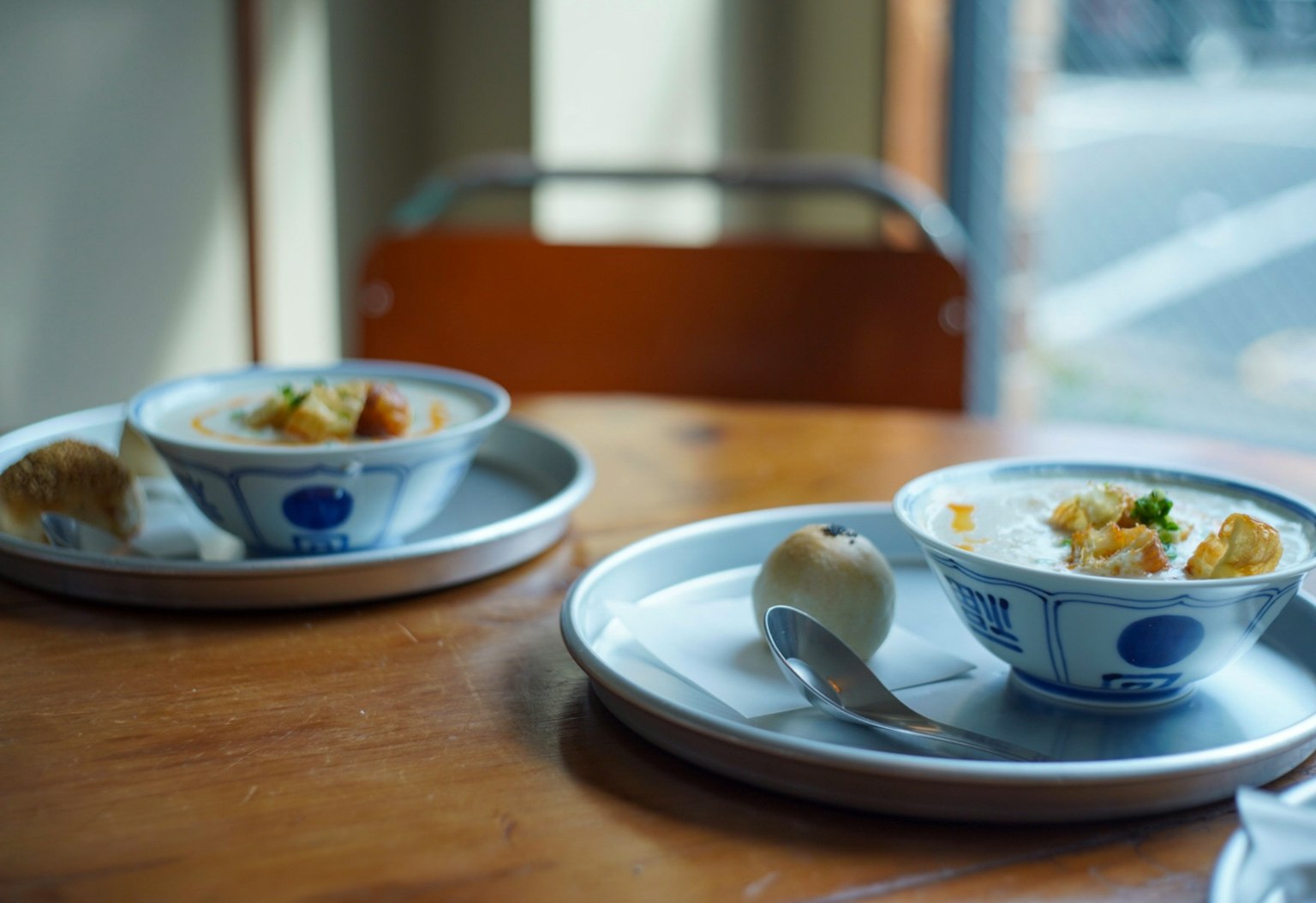 Deux bols de nourriture sur des plateaux posés sur une table en bois