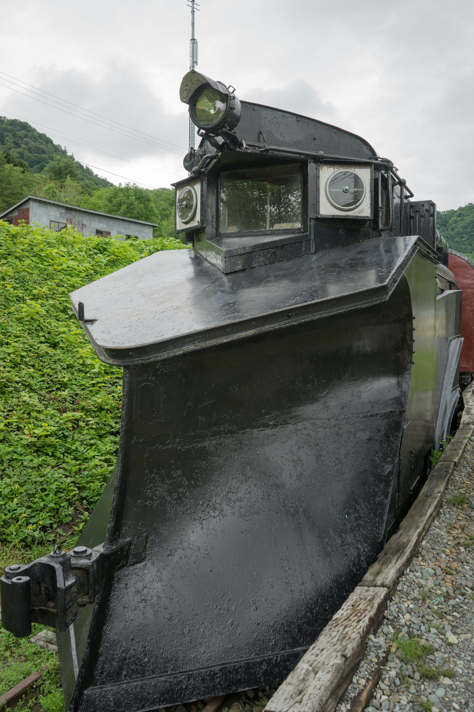 ด้านหน้ารถไฟเก็บหิมะสีดำกับภูเขาเป็นพื้นหลัง