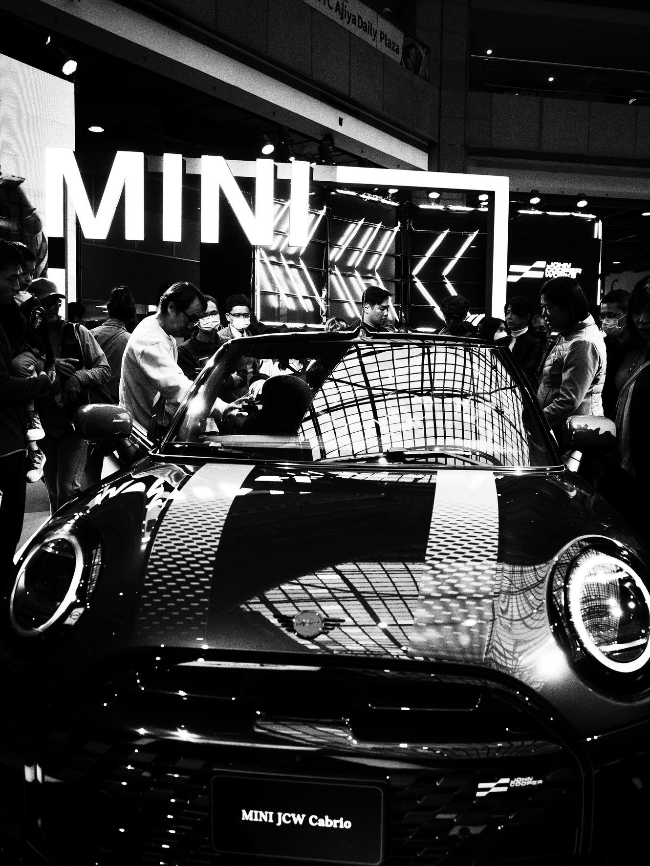 auto esposta MINI JCW Cabrio in un salone con persone