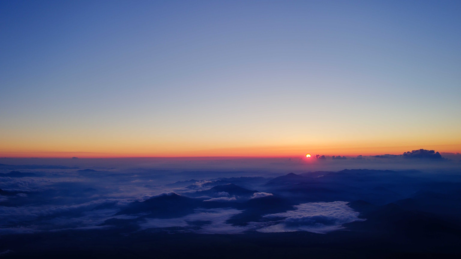 Beeindruckender Sonnenaufgang von einem Berg tiefblauer Himmel und orangefarbener Farbverlauf
