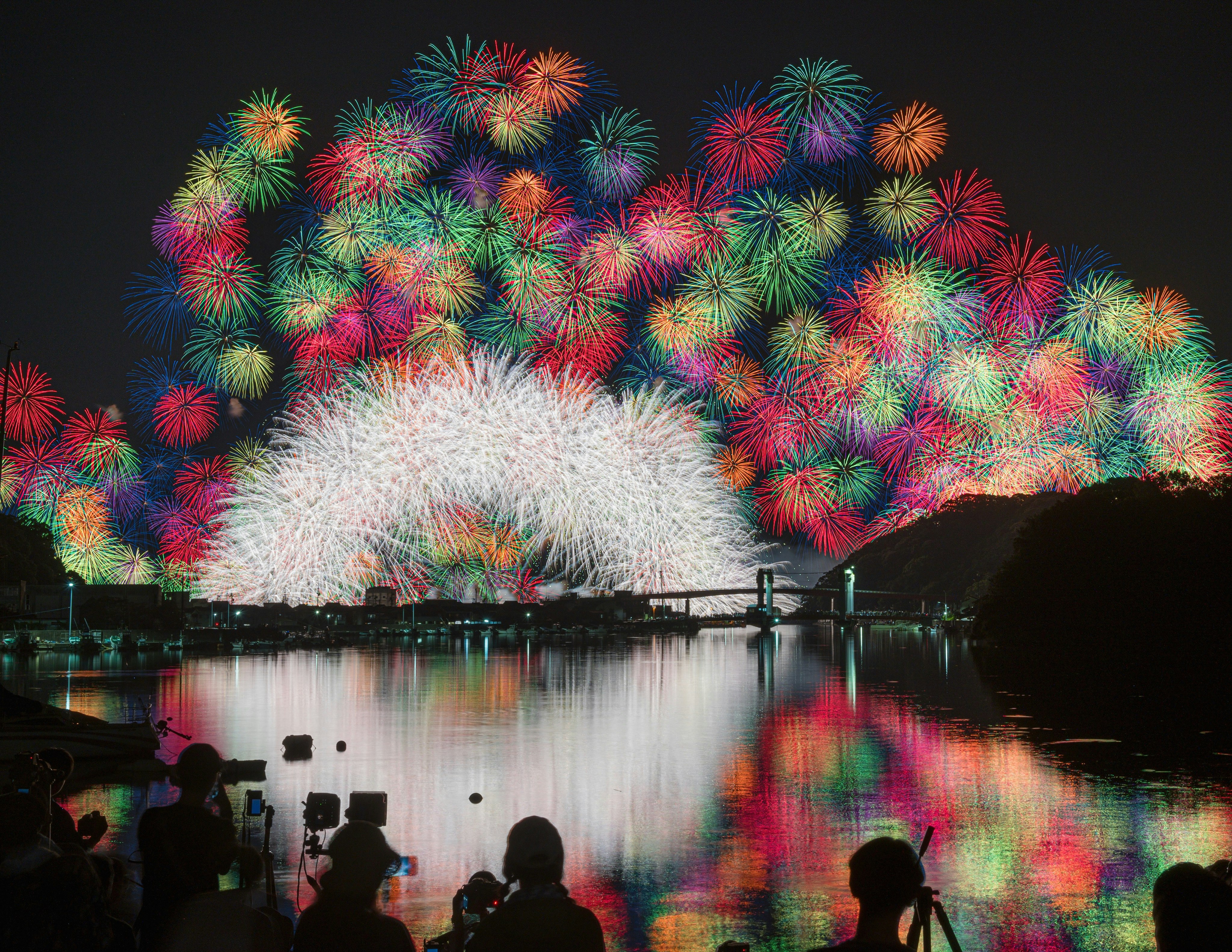 日本三重县“きほく灯篭祭”烟花映照水面，色彩斑斓的倒影
