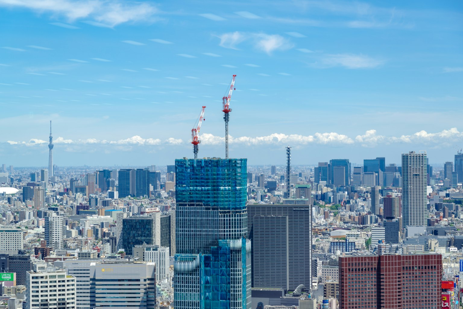 Pemandangan kota Tokyo dengan gedung pencakar langit di bawah langit biru yang cerah