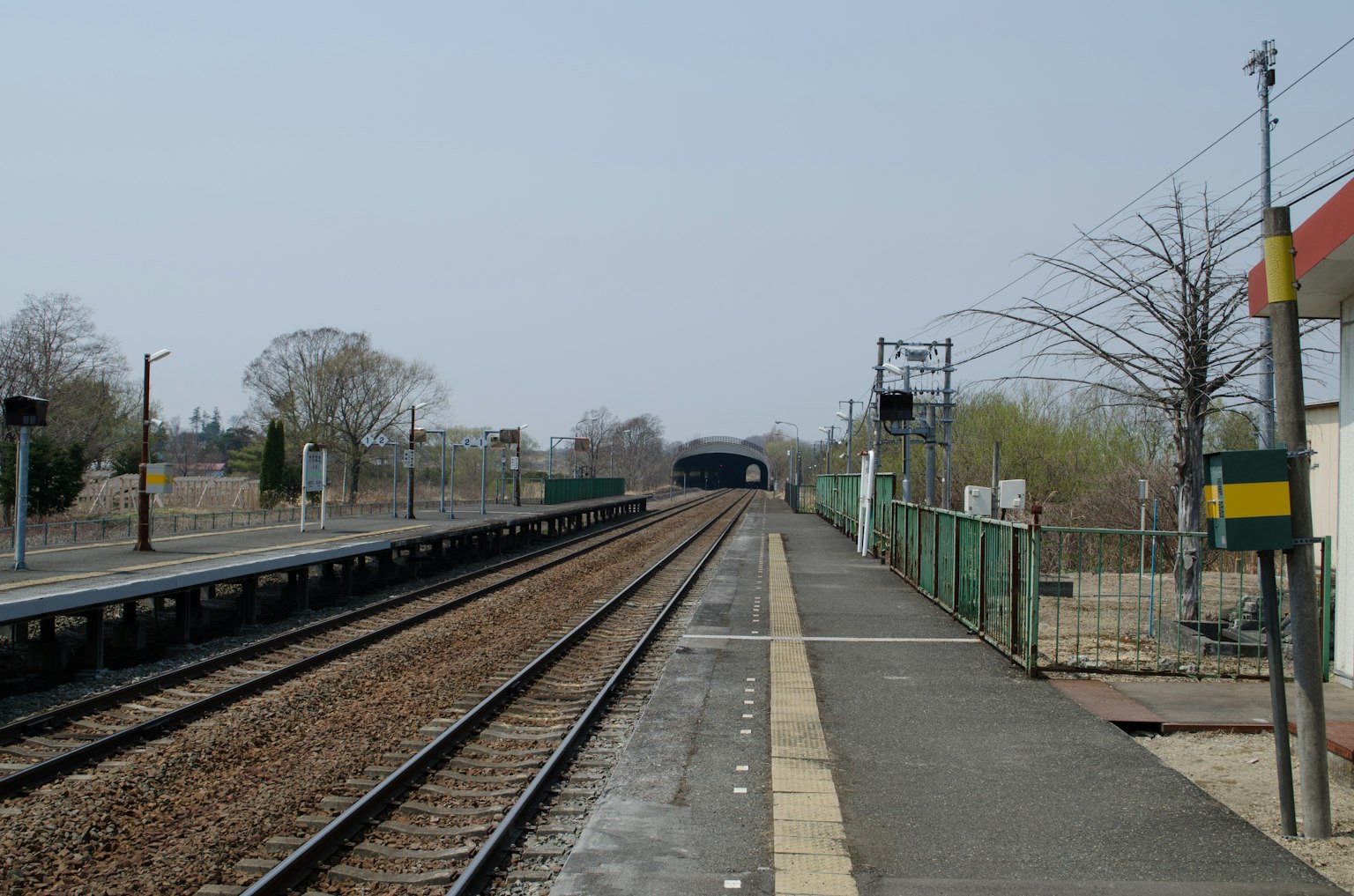 Vue d'une plateforme de gare avec des voies ferrées visibles