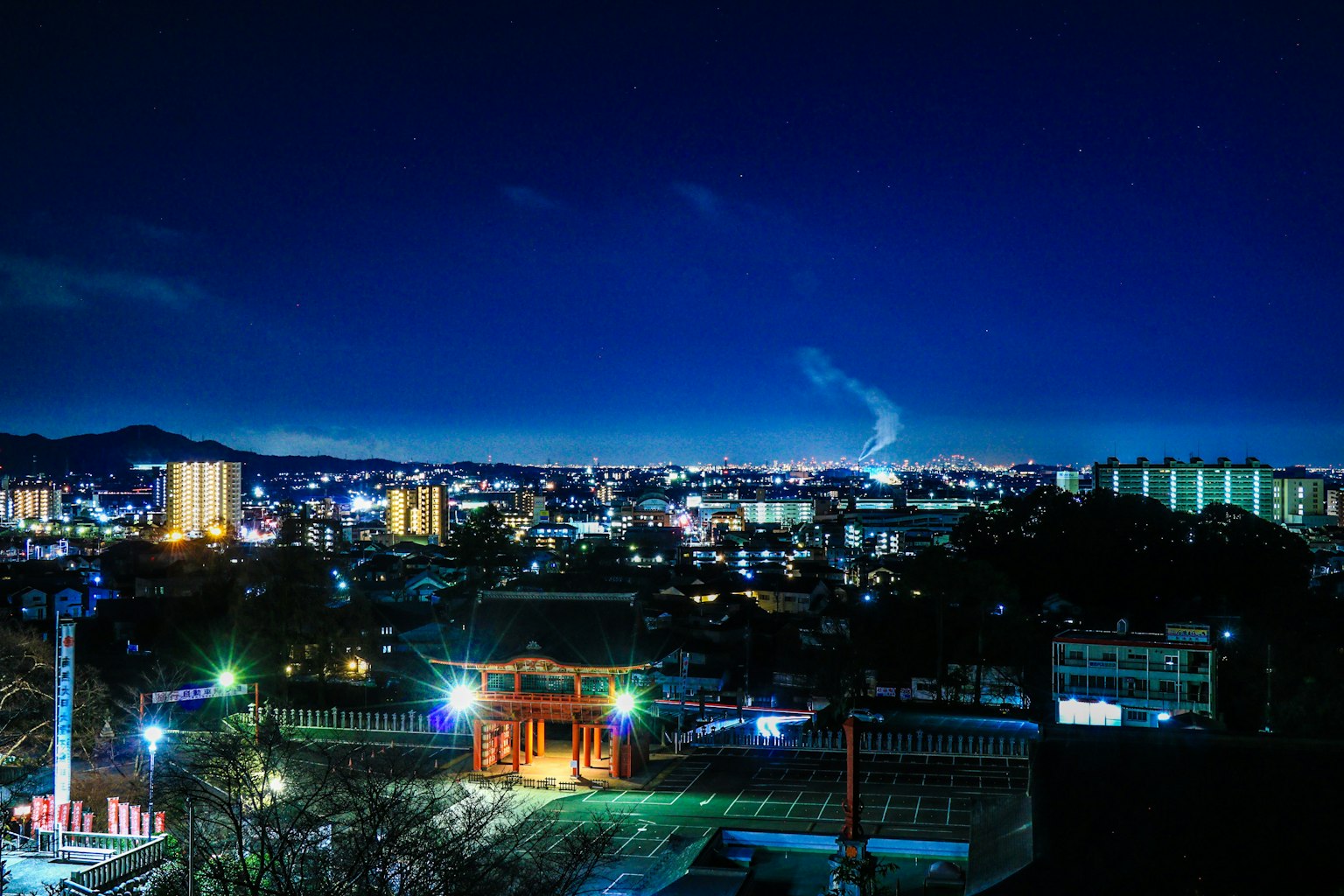 Paisaje urbano nocturno con edificios iluminados y un cielo sereno