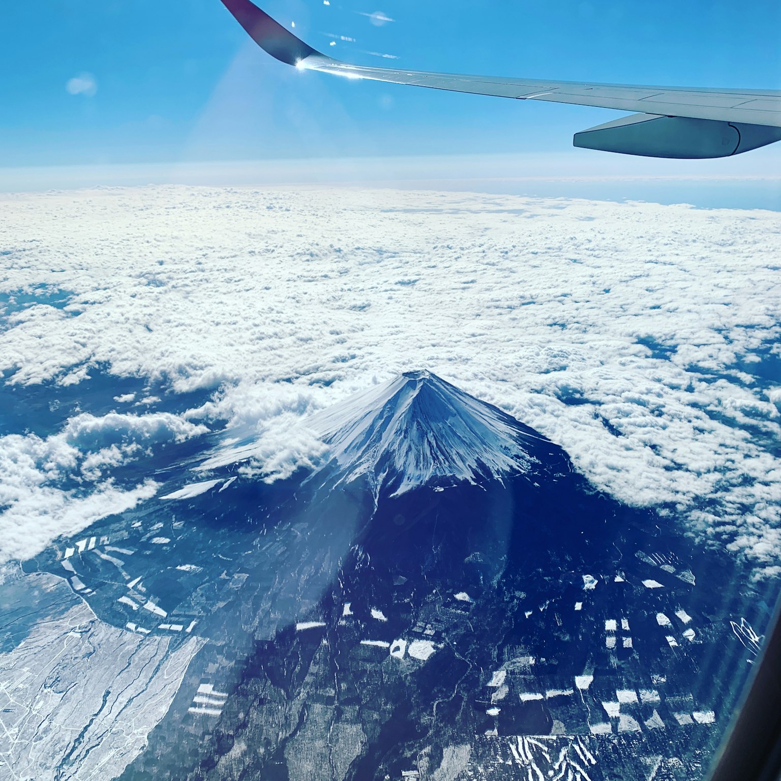 飛行機の窓から見える富士山と雲海