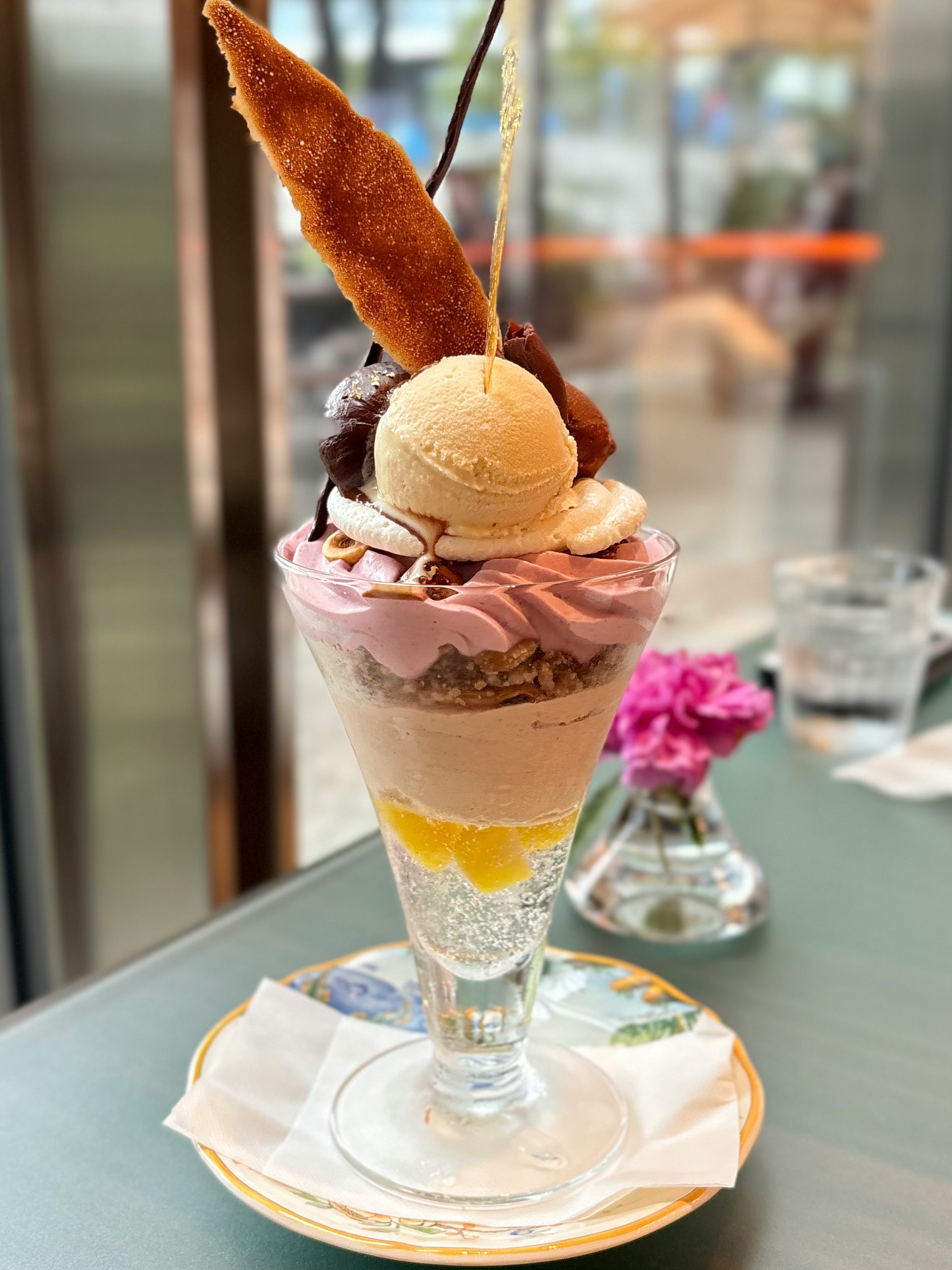 グラスパフェに乗ったコーン風のアイスとチョコソース