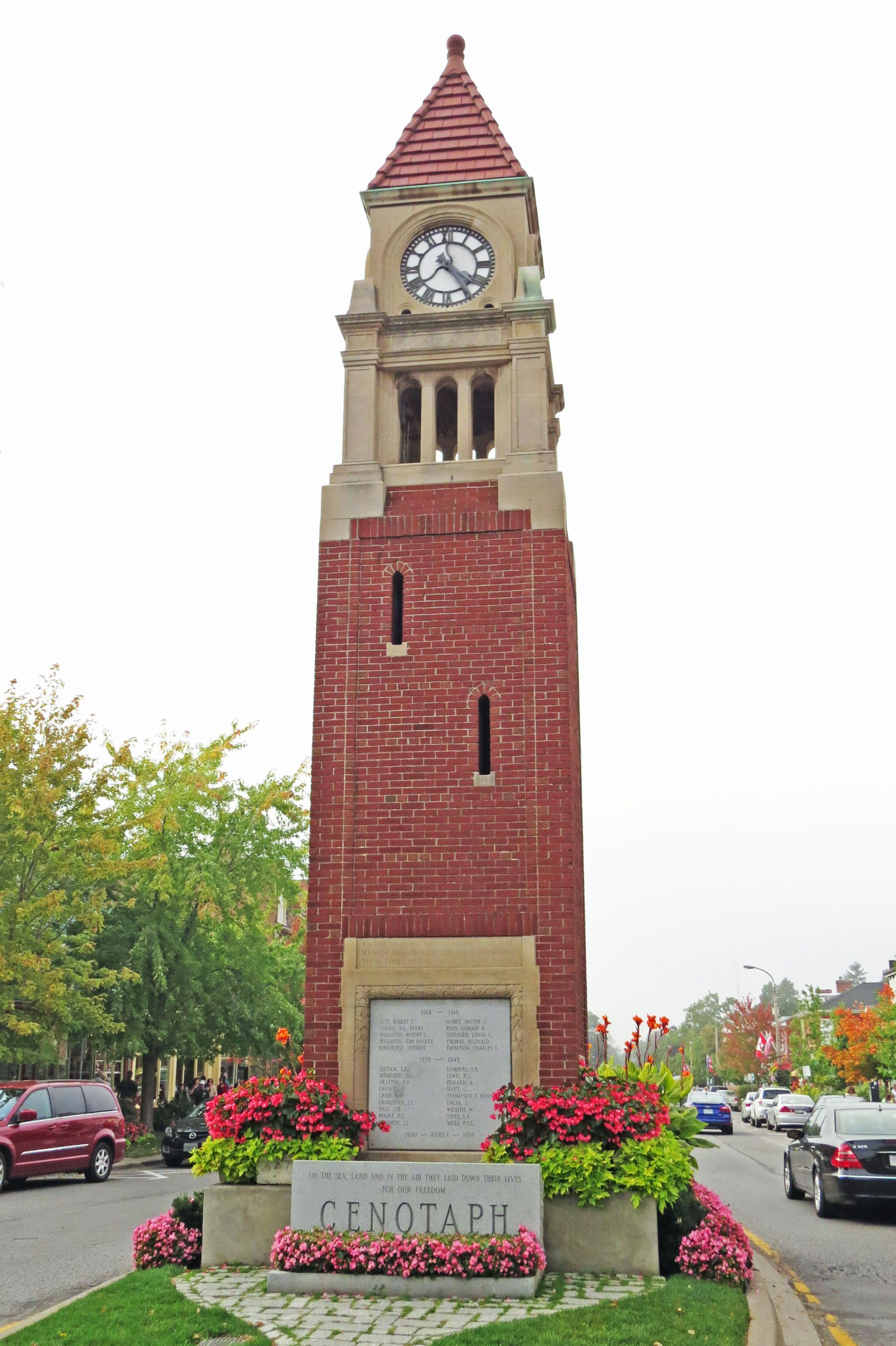 Tour de l'horloge en briques entourée de fleurs colorées