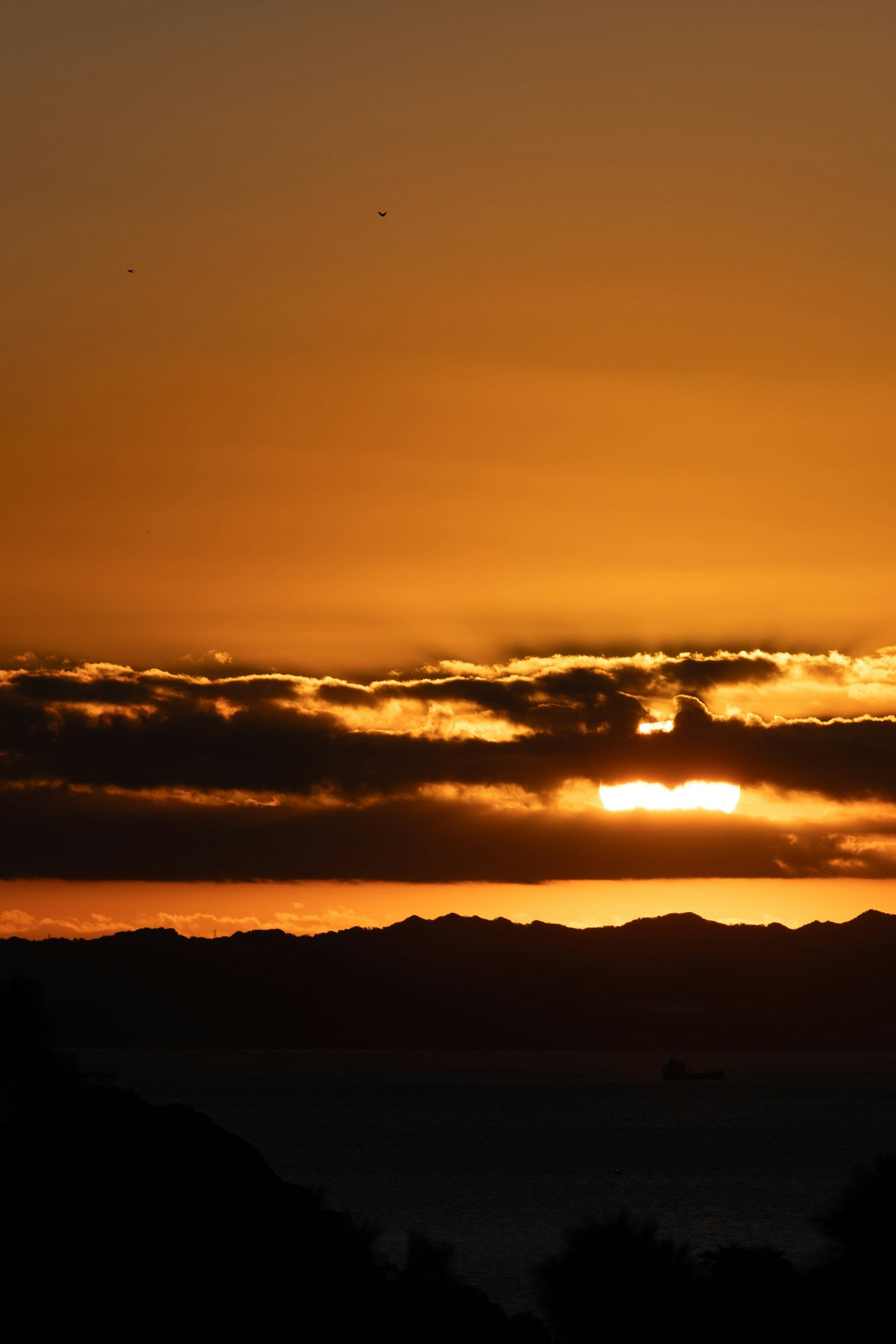 Impresionante atardecer con nubes y montañas al fondo
