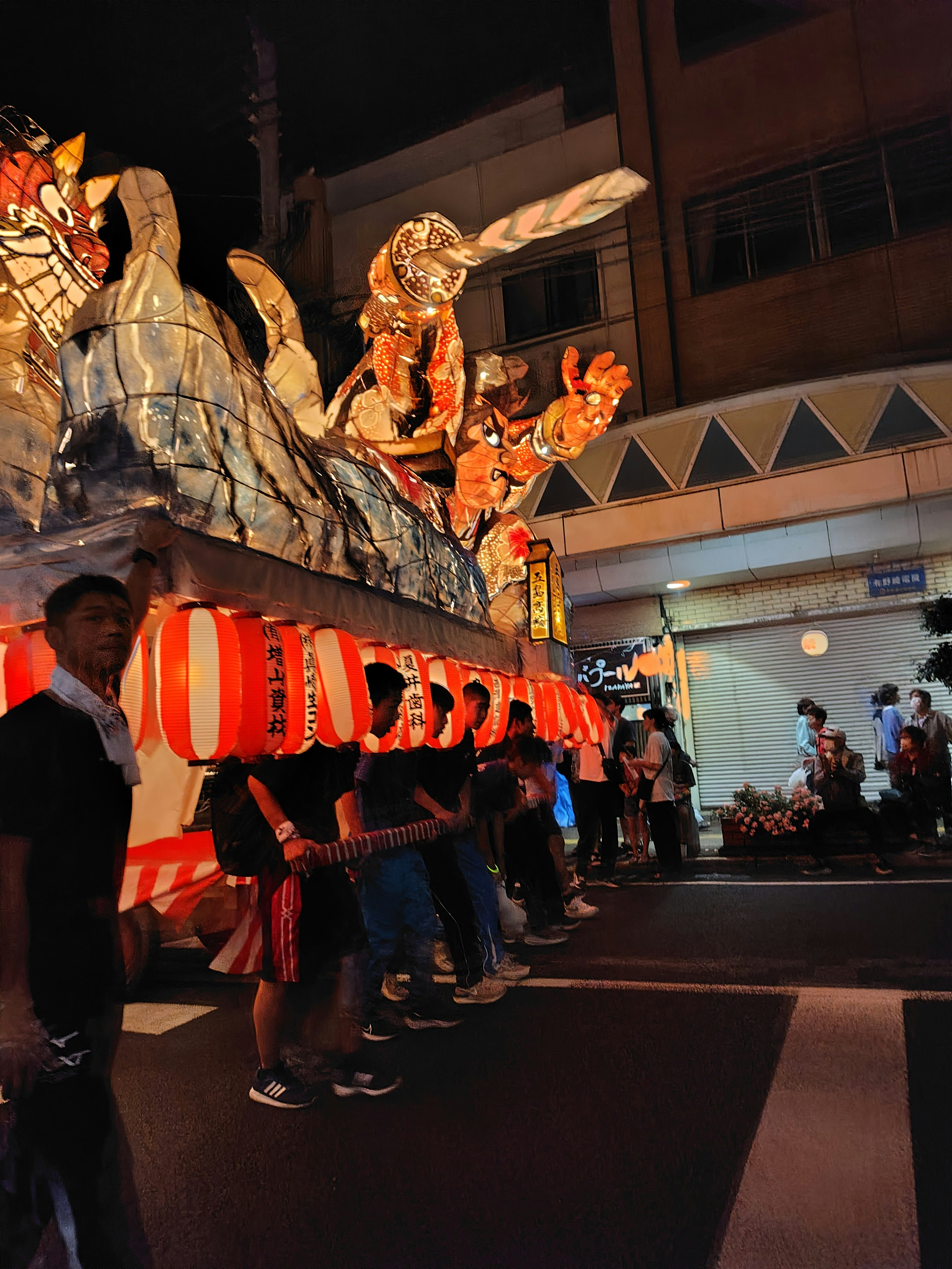 Góc phố ban đêm với các kiệu nebuta xếp hàng