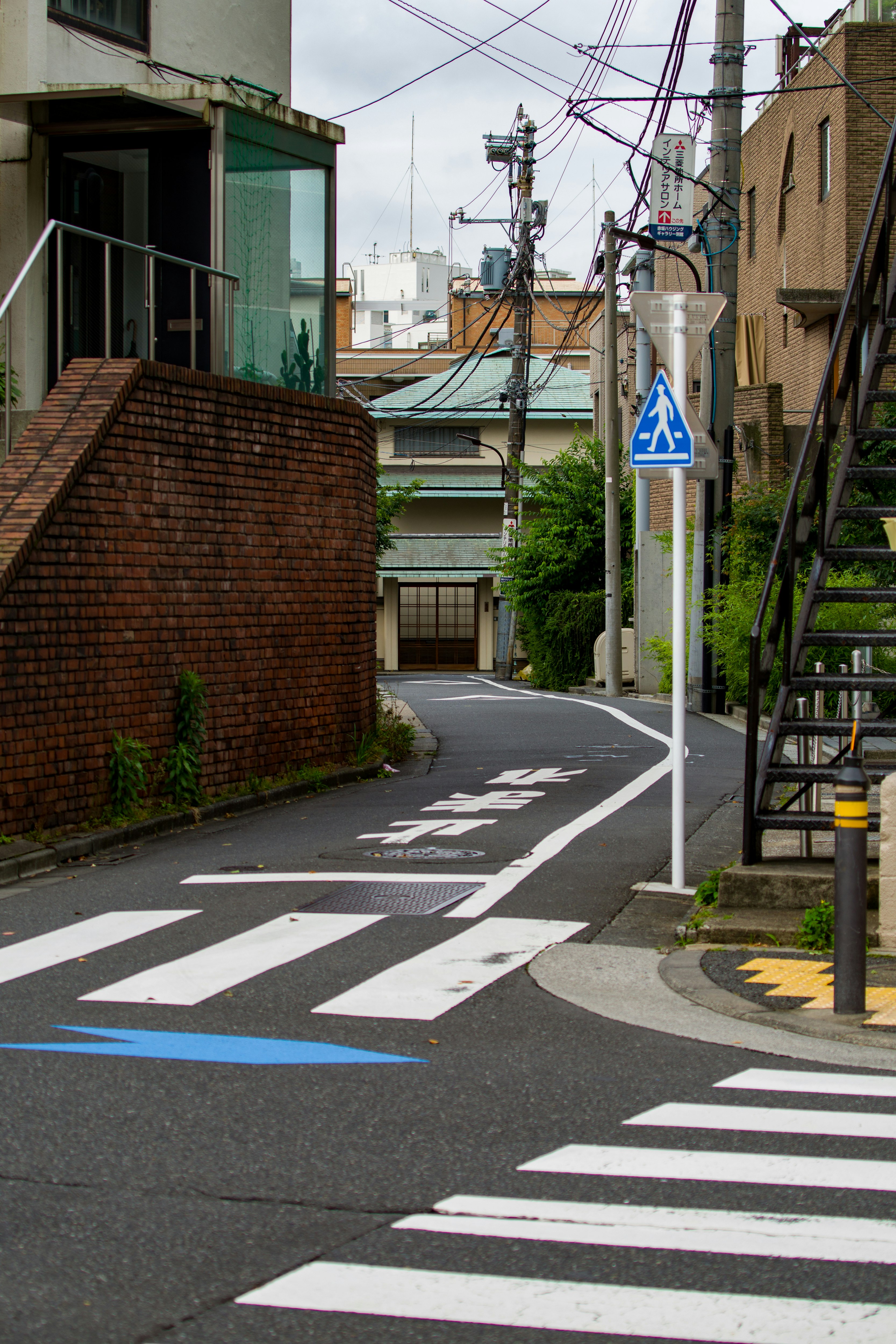 路地の横断歩道と電柱が並ぶ街角