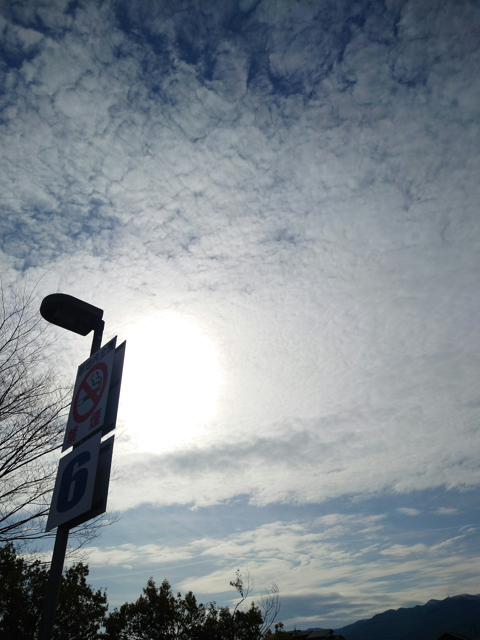 Imagen de un cartel con nubes y luz solar de fondo