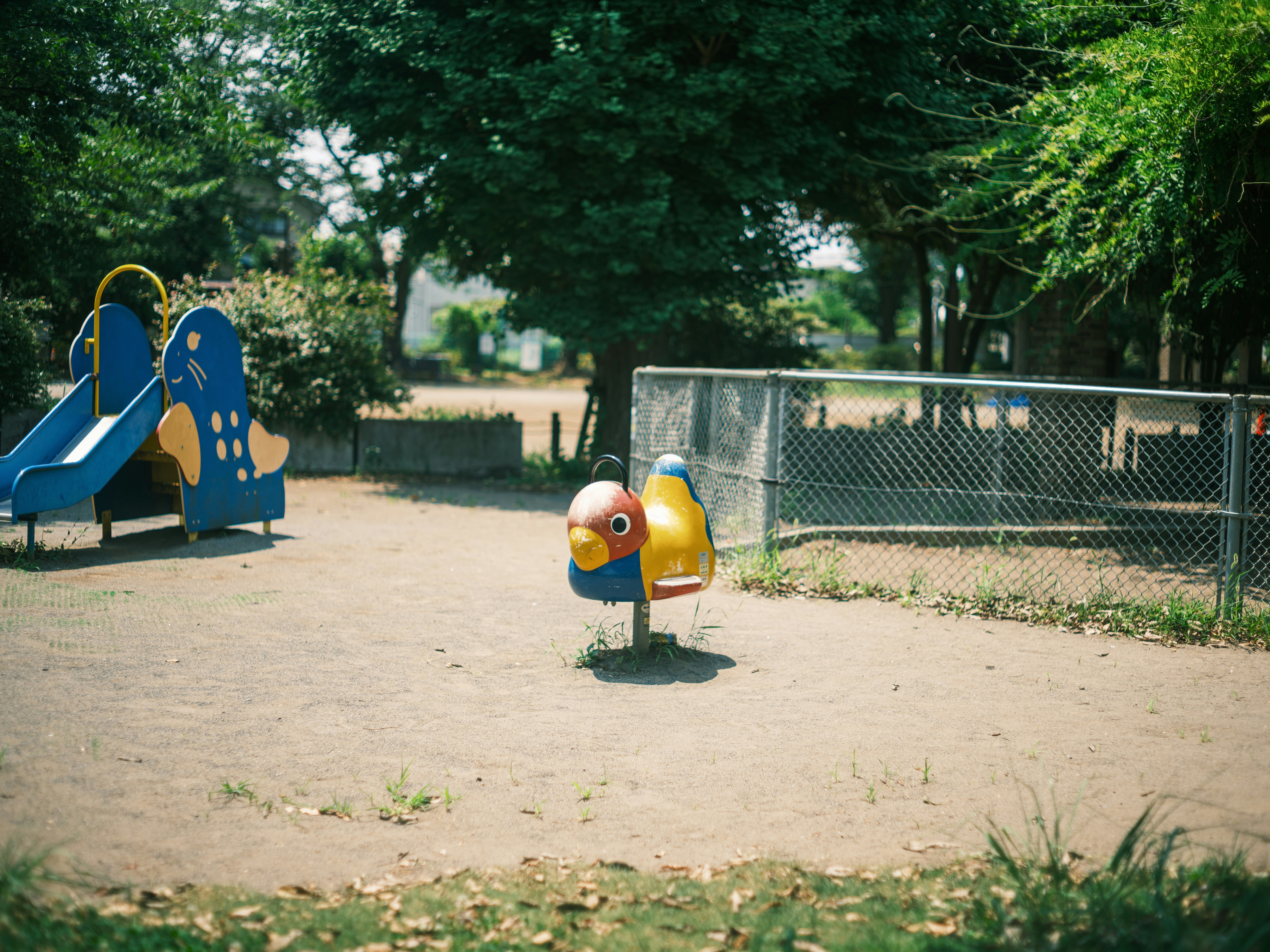 公園の遊具と砂場のある広場