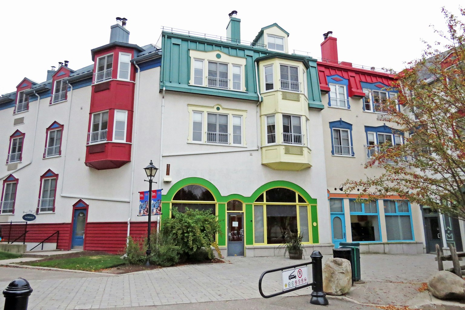 Fachada colorida de un edificio con balcones y ventanas rojas, verdes y azules
