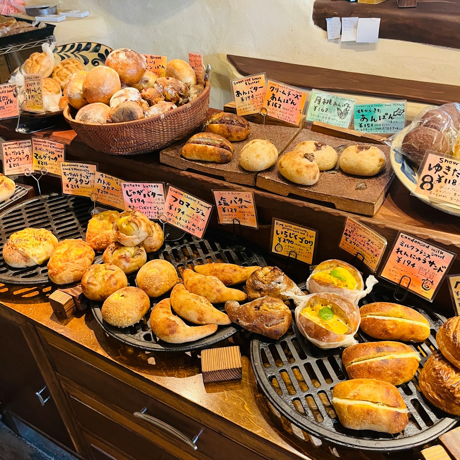 Ein Bäckerstand mit verschiedenen Brotsorten und bunten Preisschildern