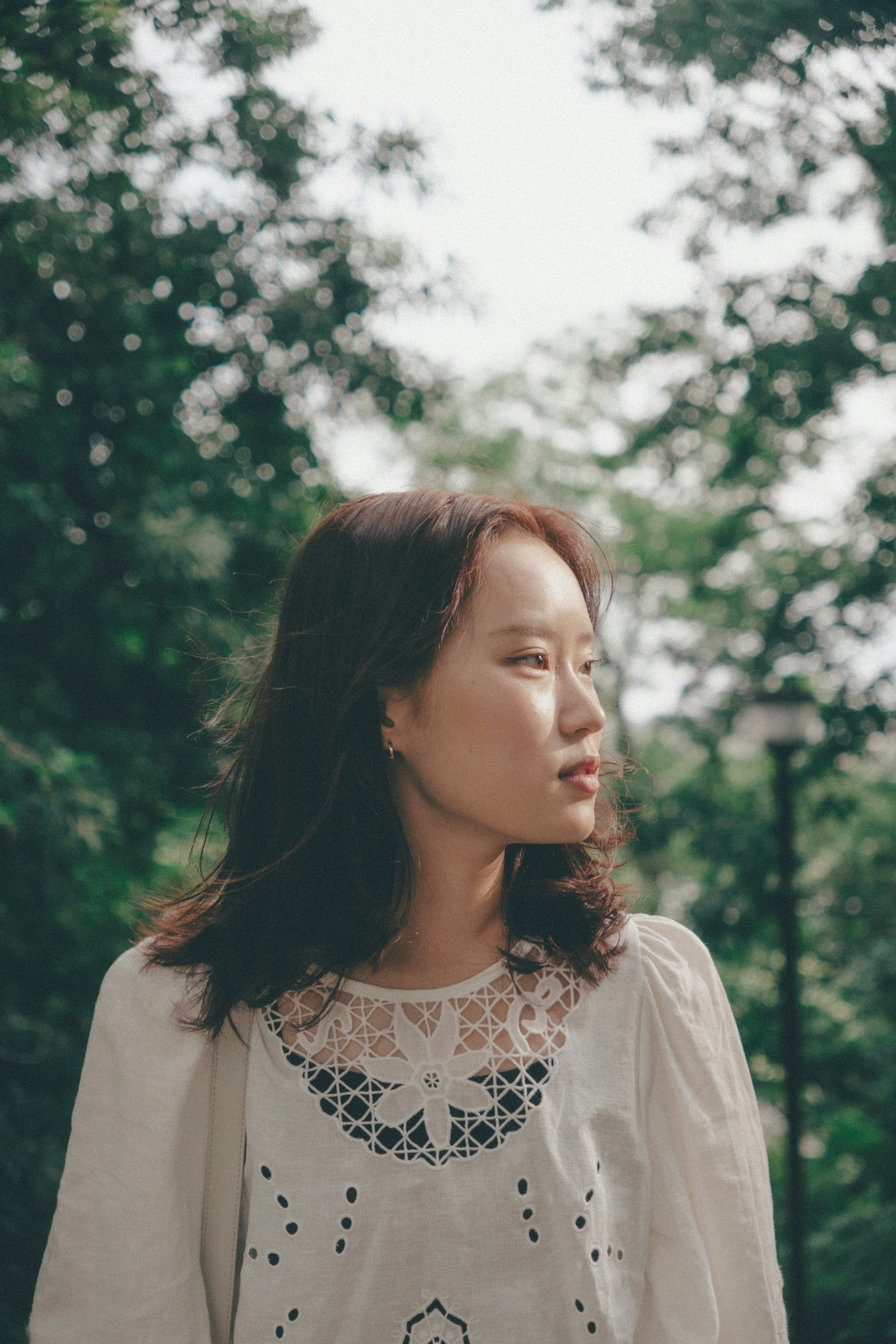 树木前微笑女性的侧脸