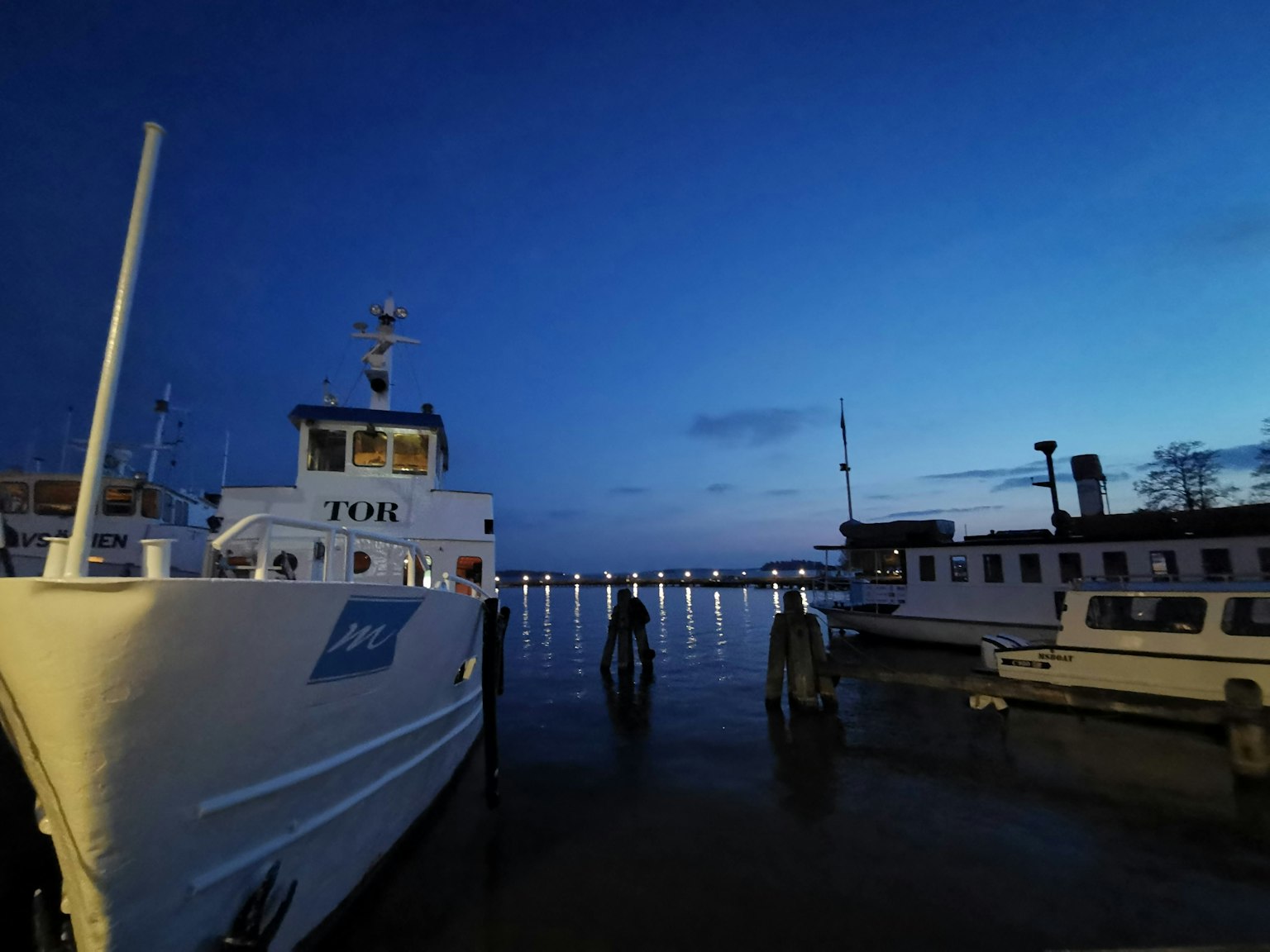 Perahu berlabuh di malam hari dengan permukaan air tenang