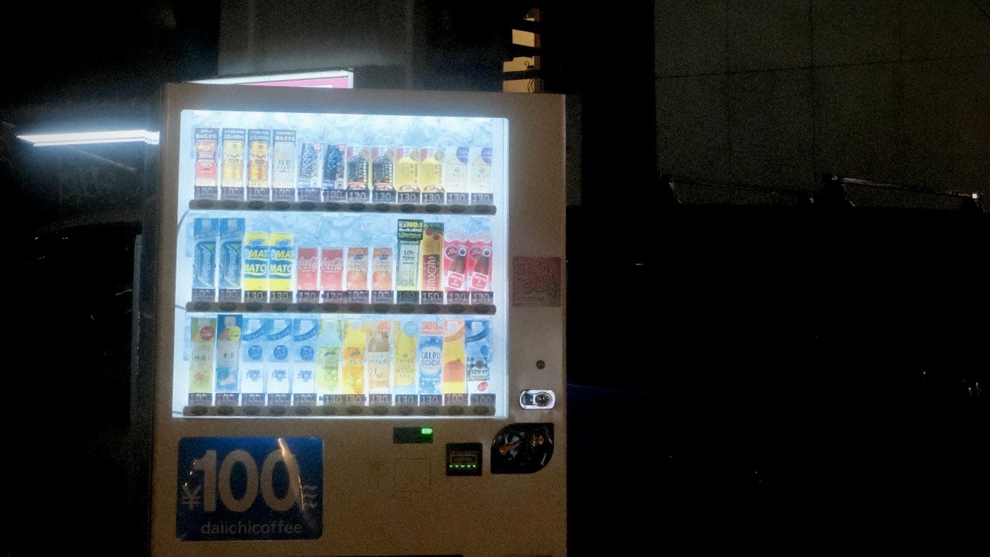 夜の自動販売機に並ぶ飲料のライトアップ
