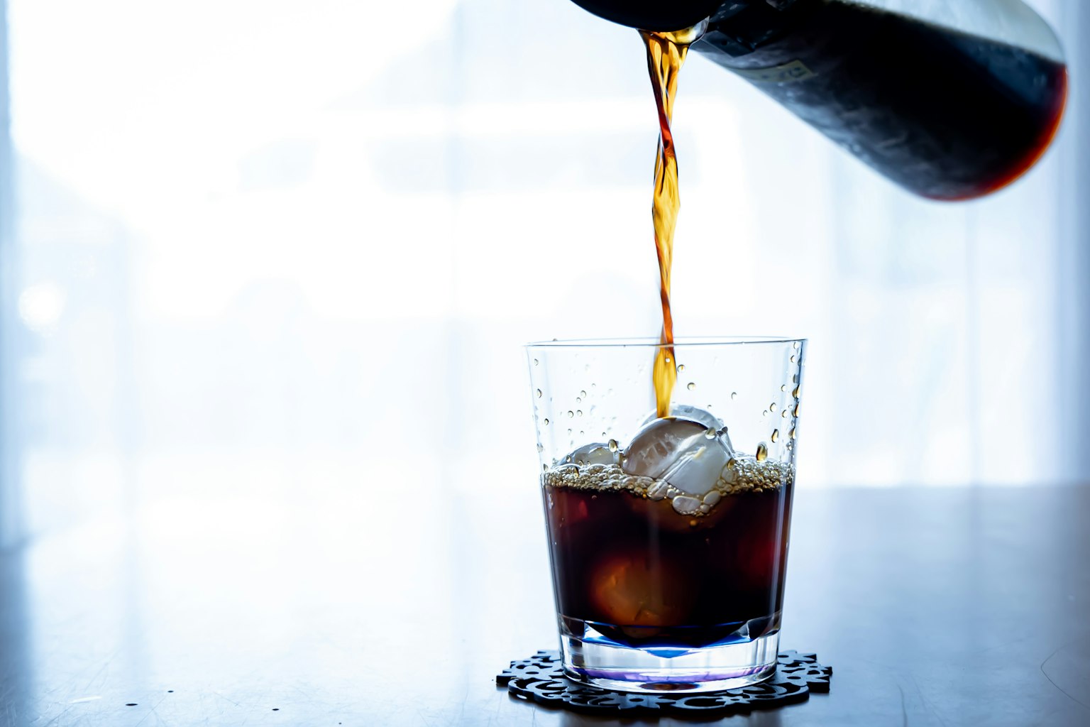 Kopi dituangkan ke dalam gelas berisi es