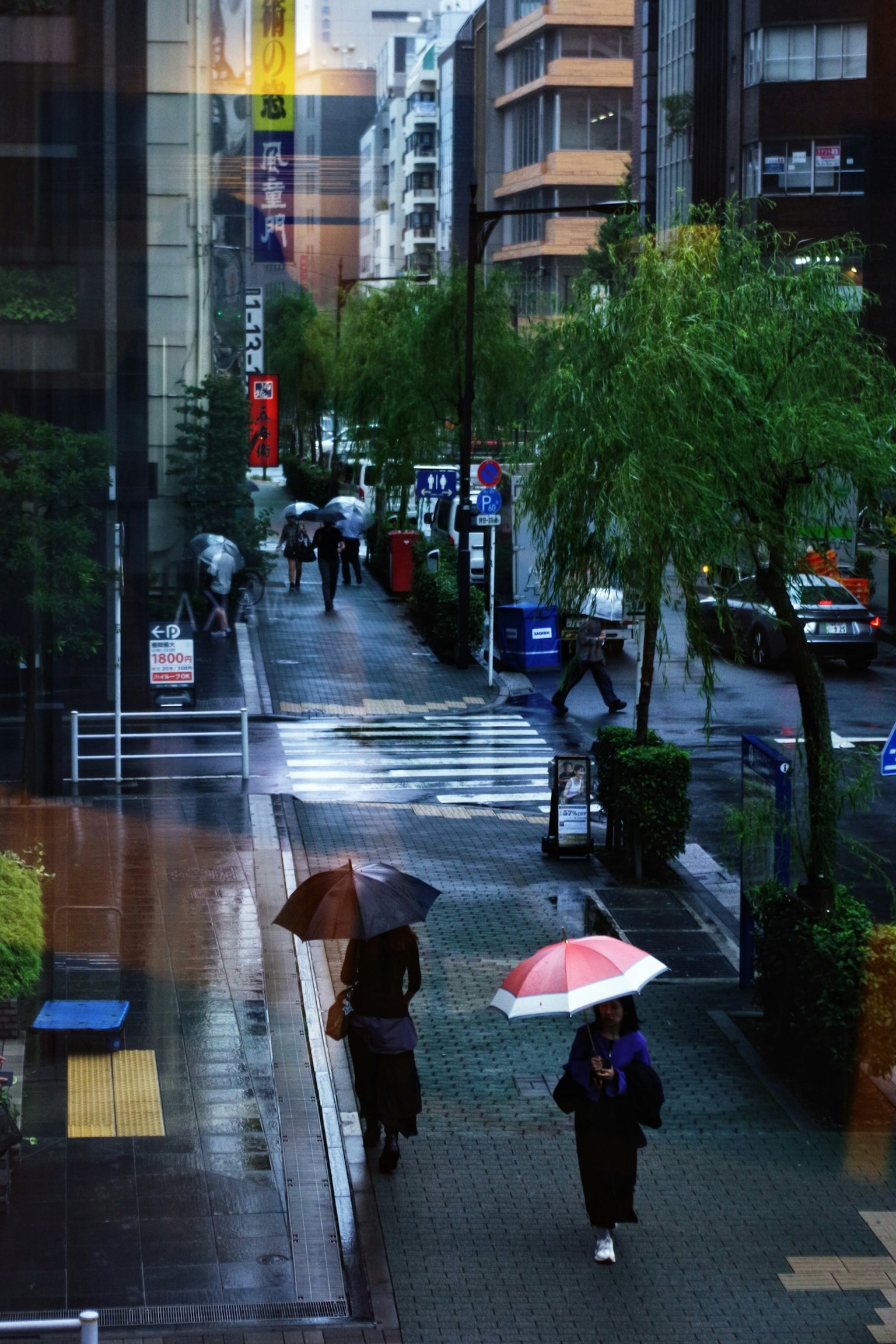 Des gens marchant avec des parapluies dans une rue pluvieuse de Tokyo