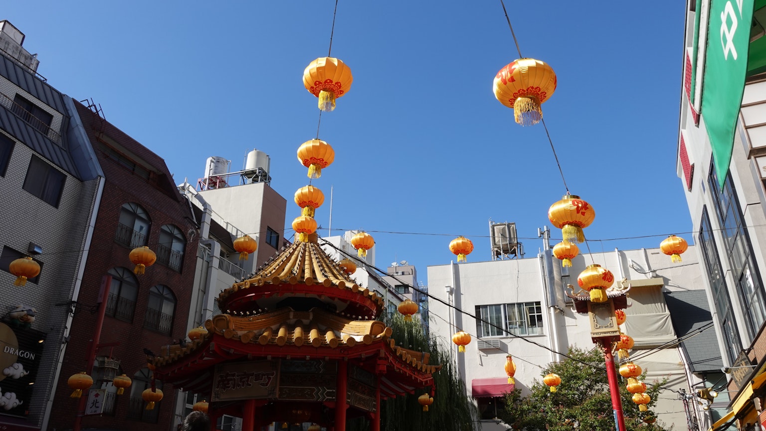 藍天下懸掛的橙色燈籠與傳統建築