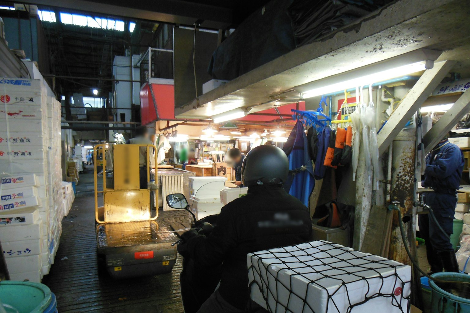 รถยกทำงานในตลาดภายในที่มีกล่องและคนงาน