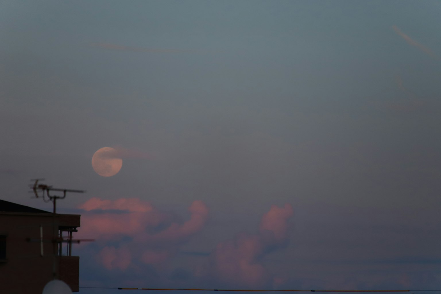 Luna piena nel cielo serale con nuvole morbide