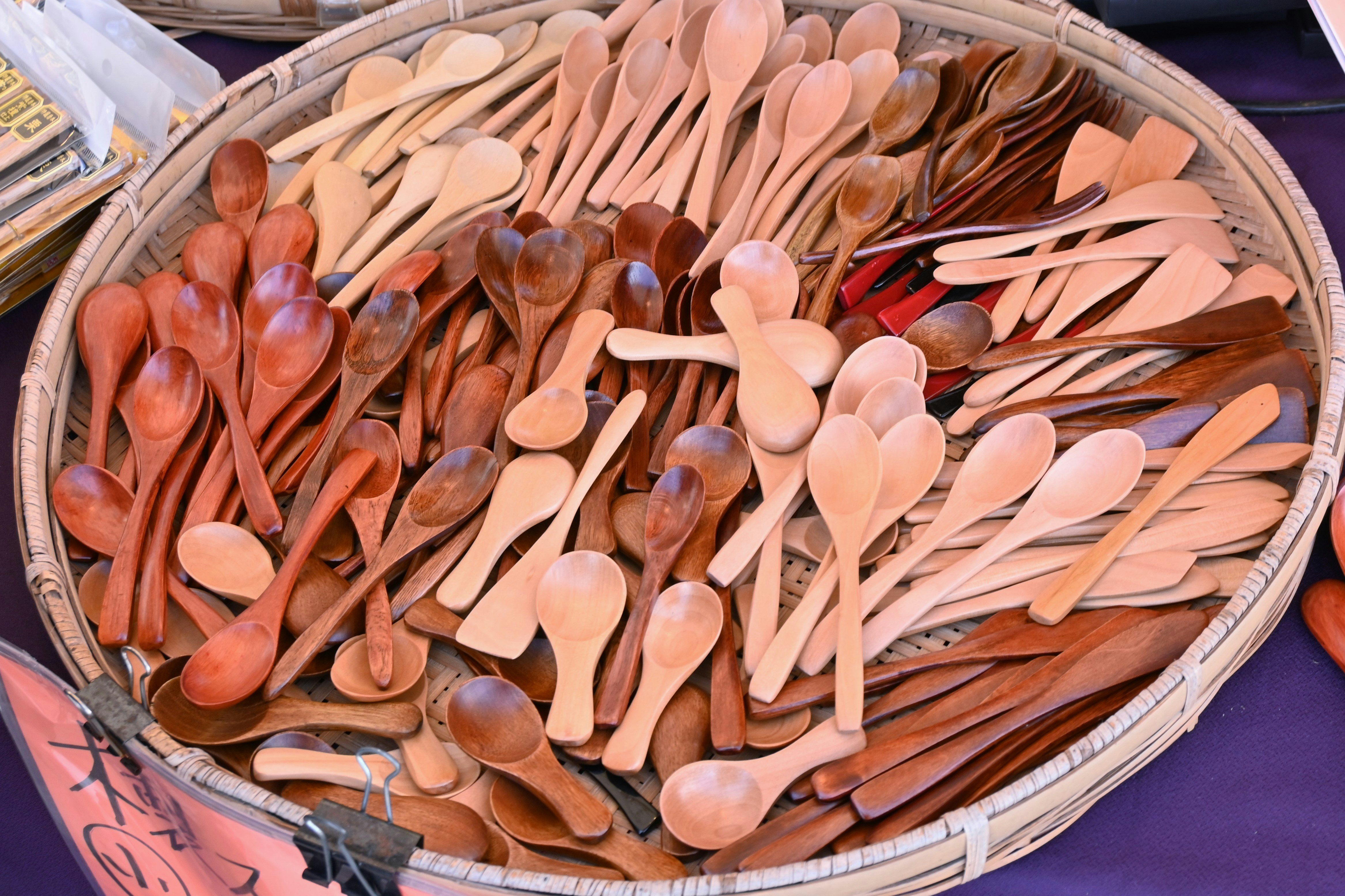 cuillères et spatules en bois disposées dans un panier en bambou