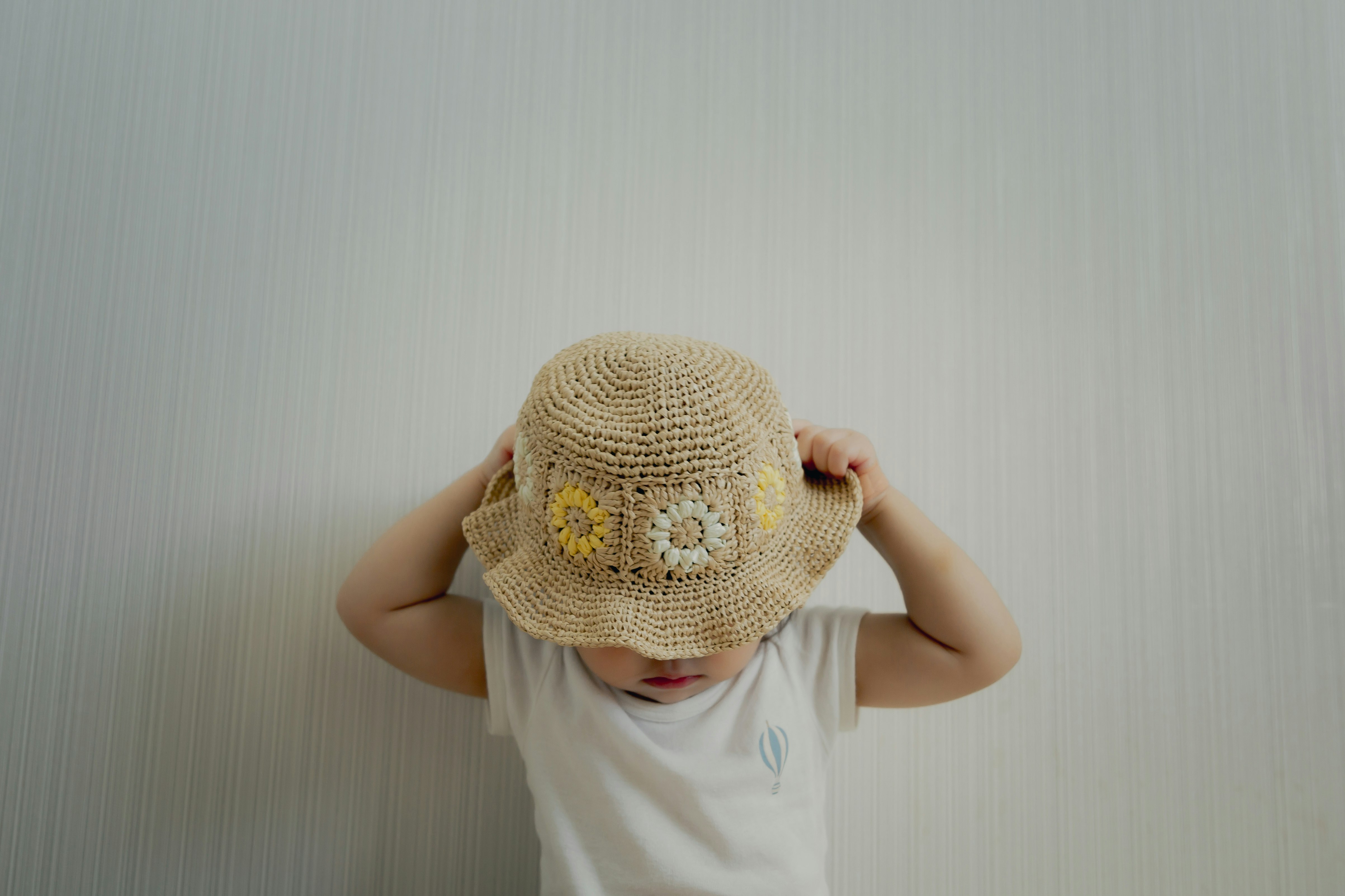 麦わら帽子をかぶった子どもの後ろ姿