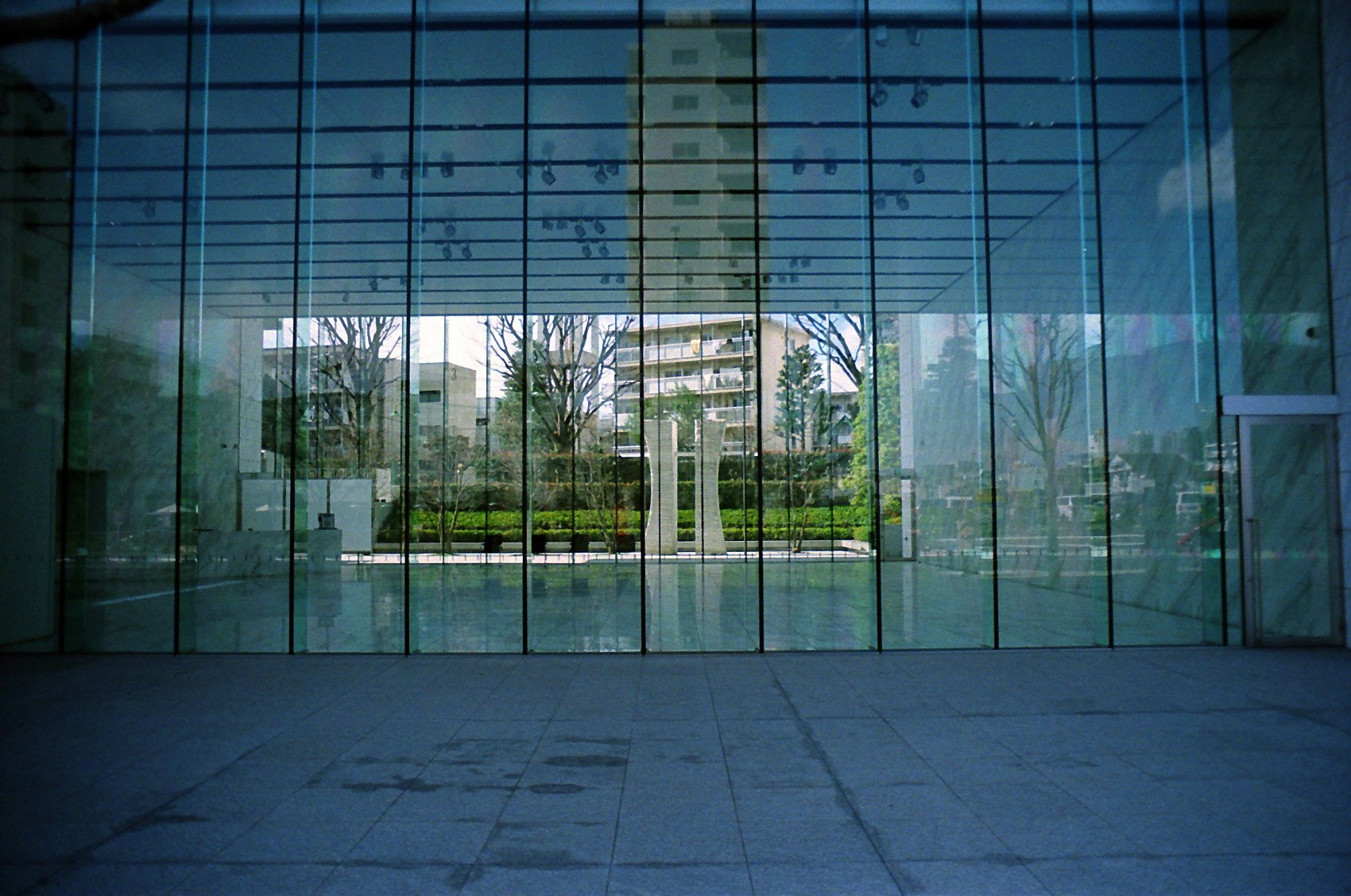 Vista a través de una entrada de vidrio en arco hacia un patio interior