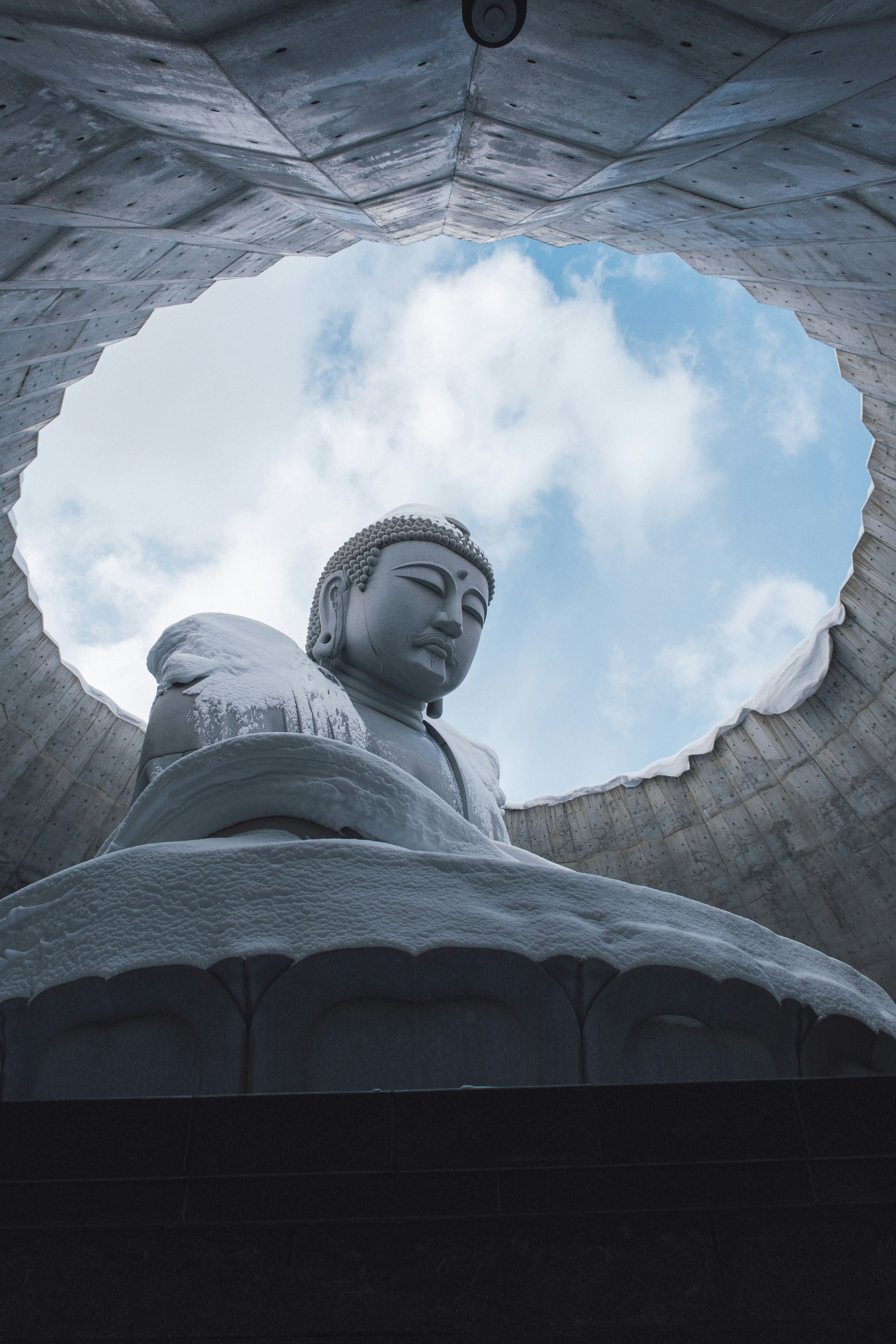空を見上げる大仏像の下からの構図