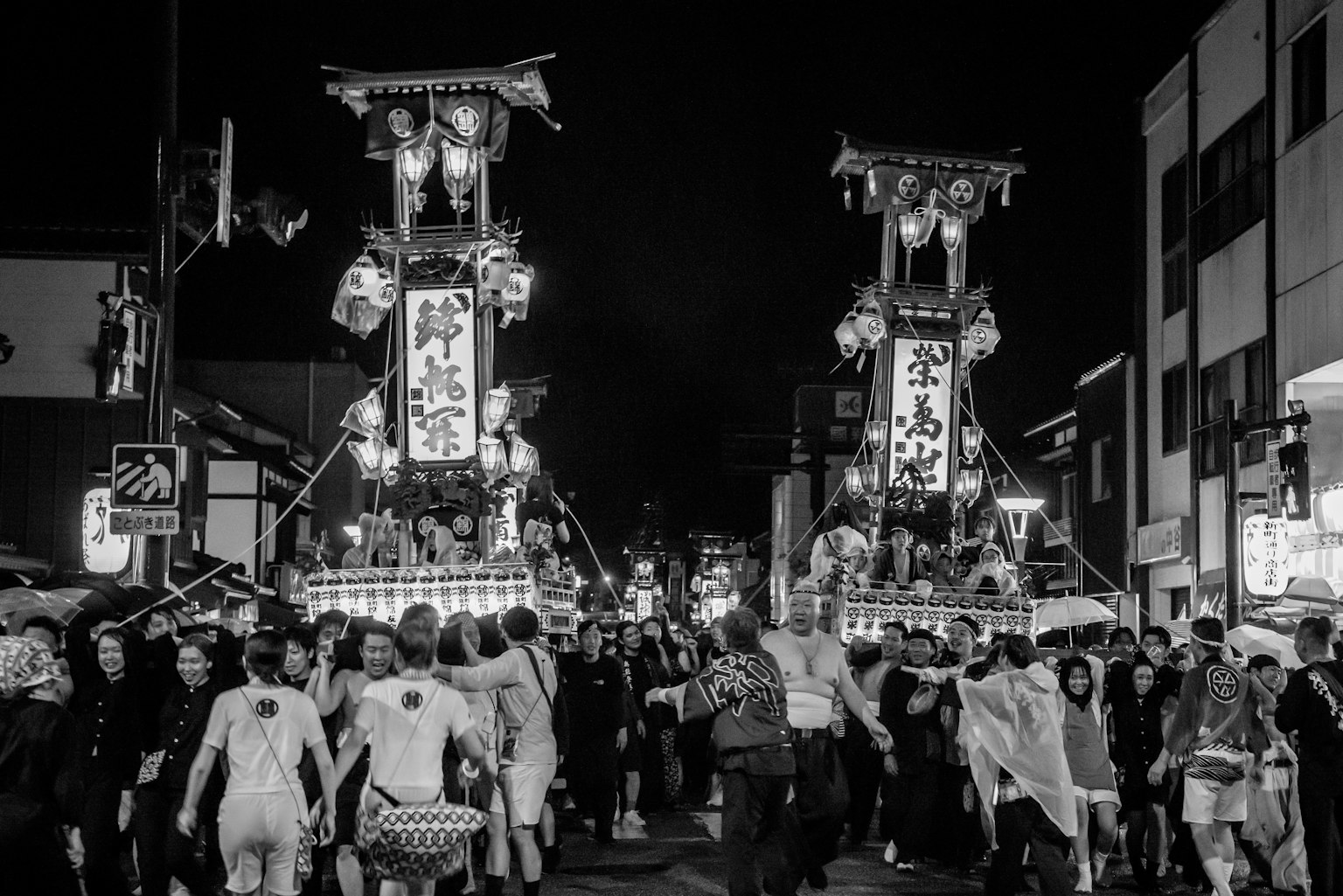 Foule rassemblée lors d'un festival nocturne avec des chars traditionnels