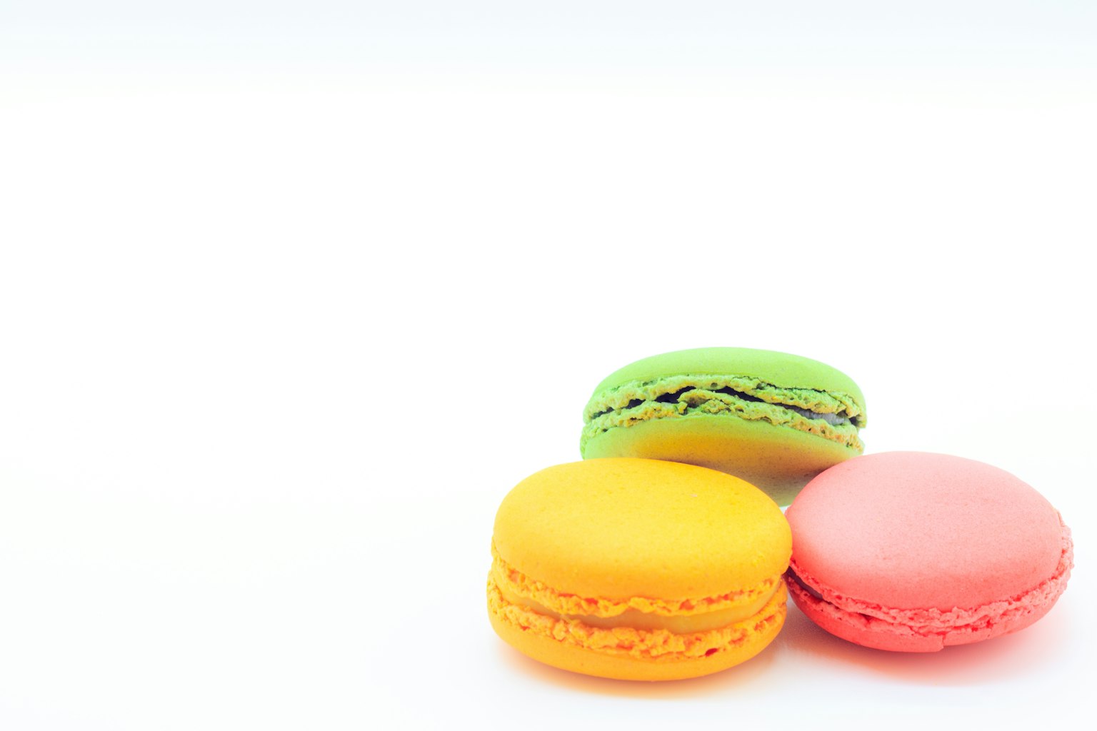 Ba chiếc macarons màu vàng hồng và xanh