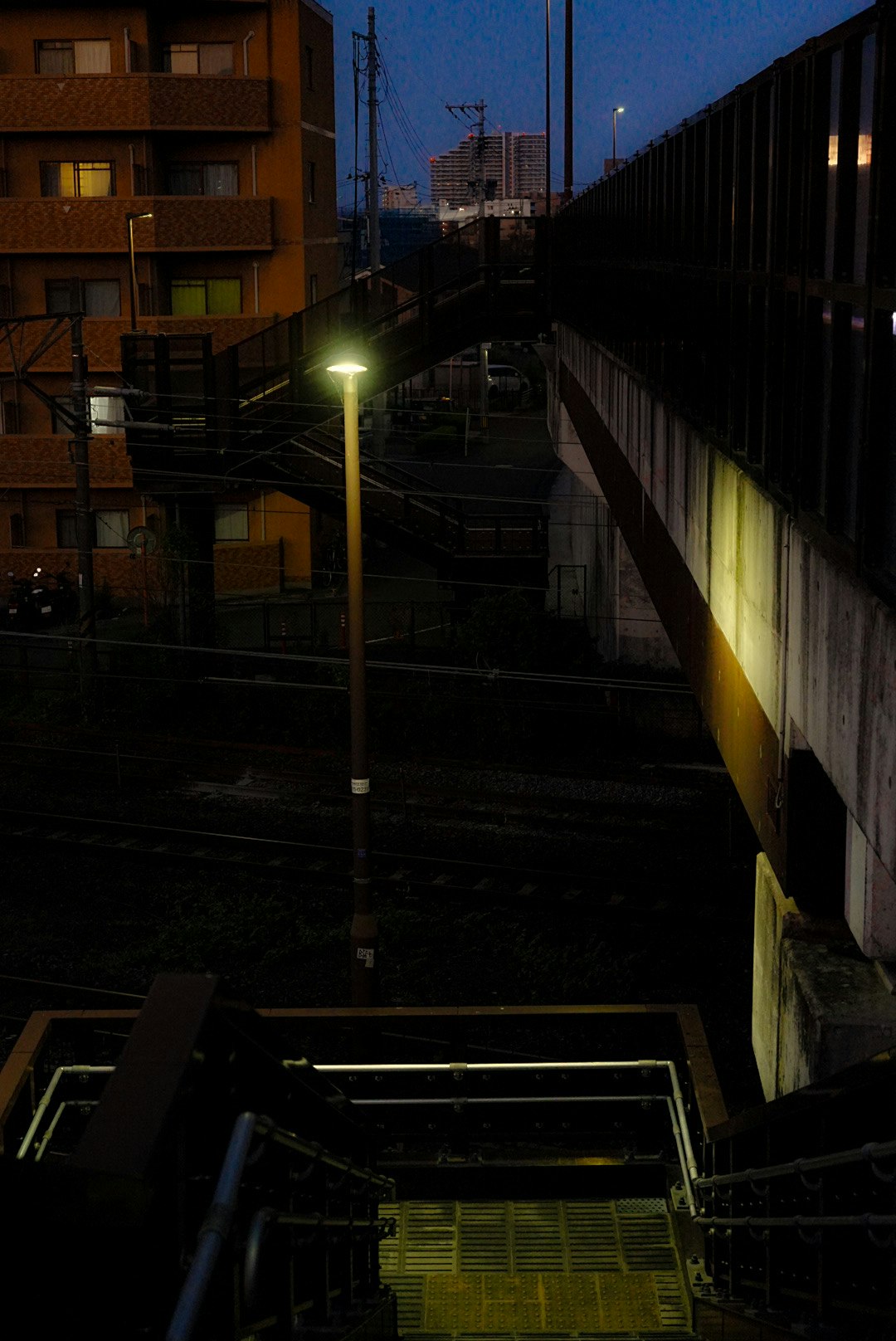 夕暮れの路地に並ぶ建物と街灯の光